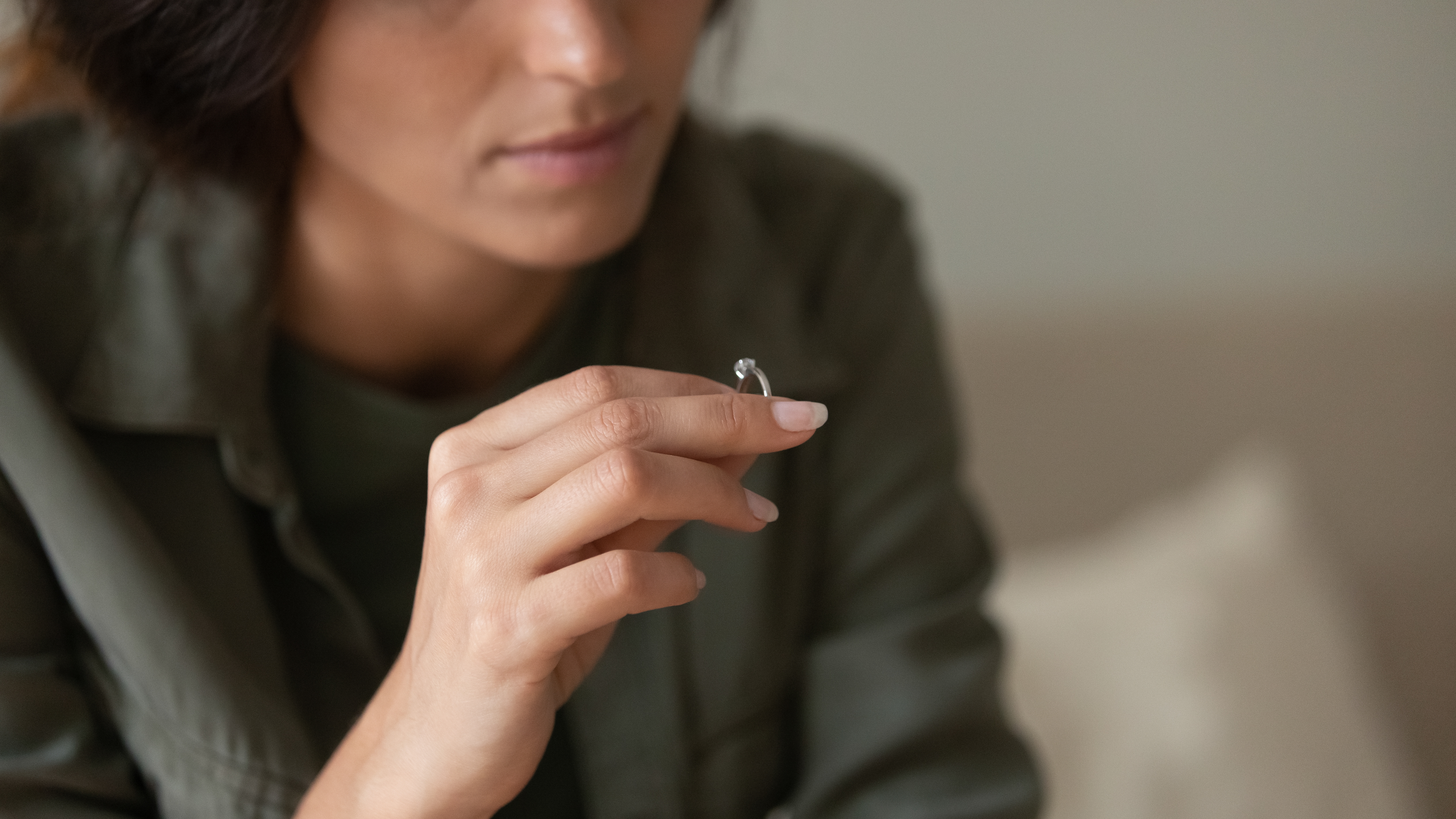 Eine Frau, die traurig dreinschaut, während sie einen Ring hält | Quelle: Shutterstock
