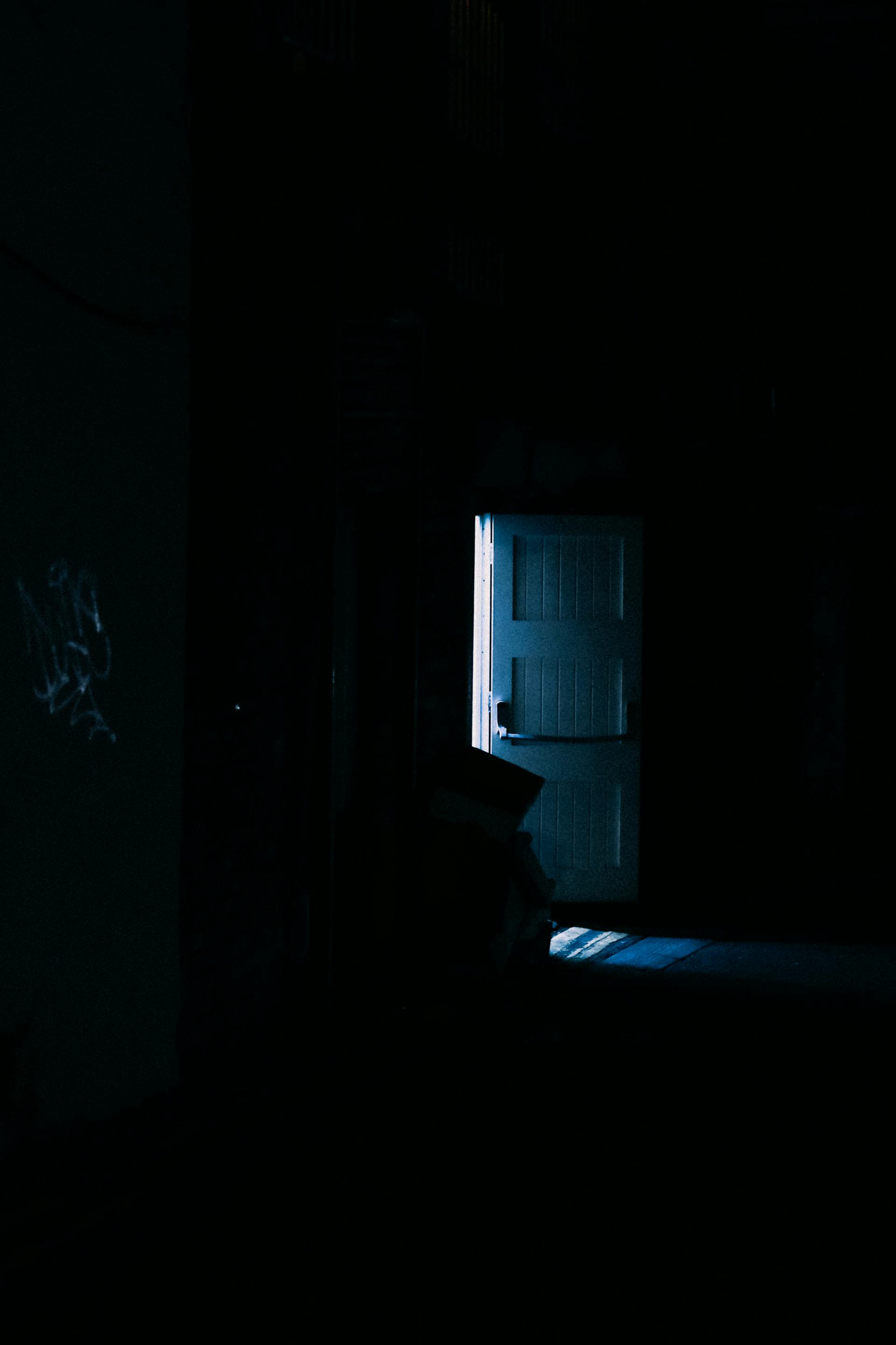 Eine Tür in einem abgedunkelten Raum | Quelle: Pexels