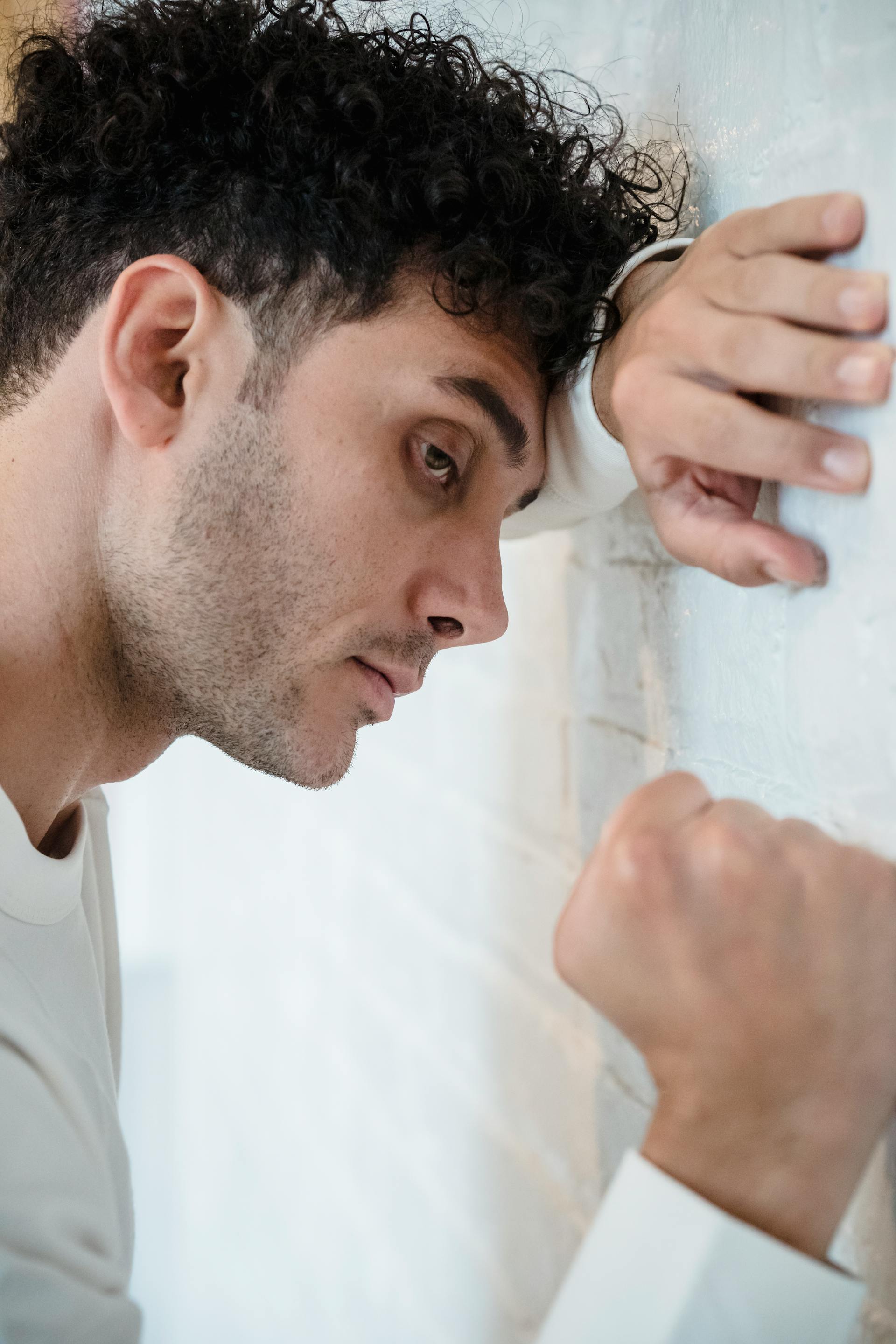 Ein Mann drückt seine Faust gegen eine Wand | Quelle: Pexels
