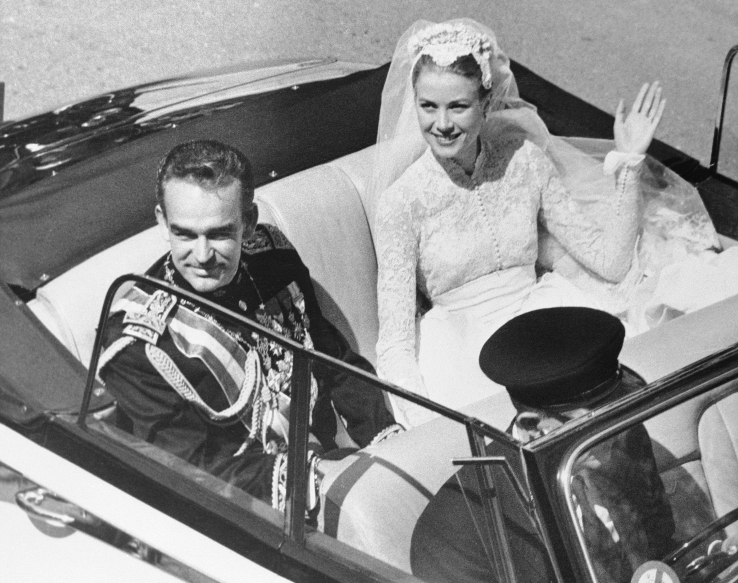 Fürst Rainier III. und Grace Kelly im offenen Auto nach ihrer kirchlichen Trauung am 19. April 1956 in Monaco. | Quelle: Getty Images