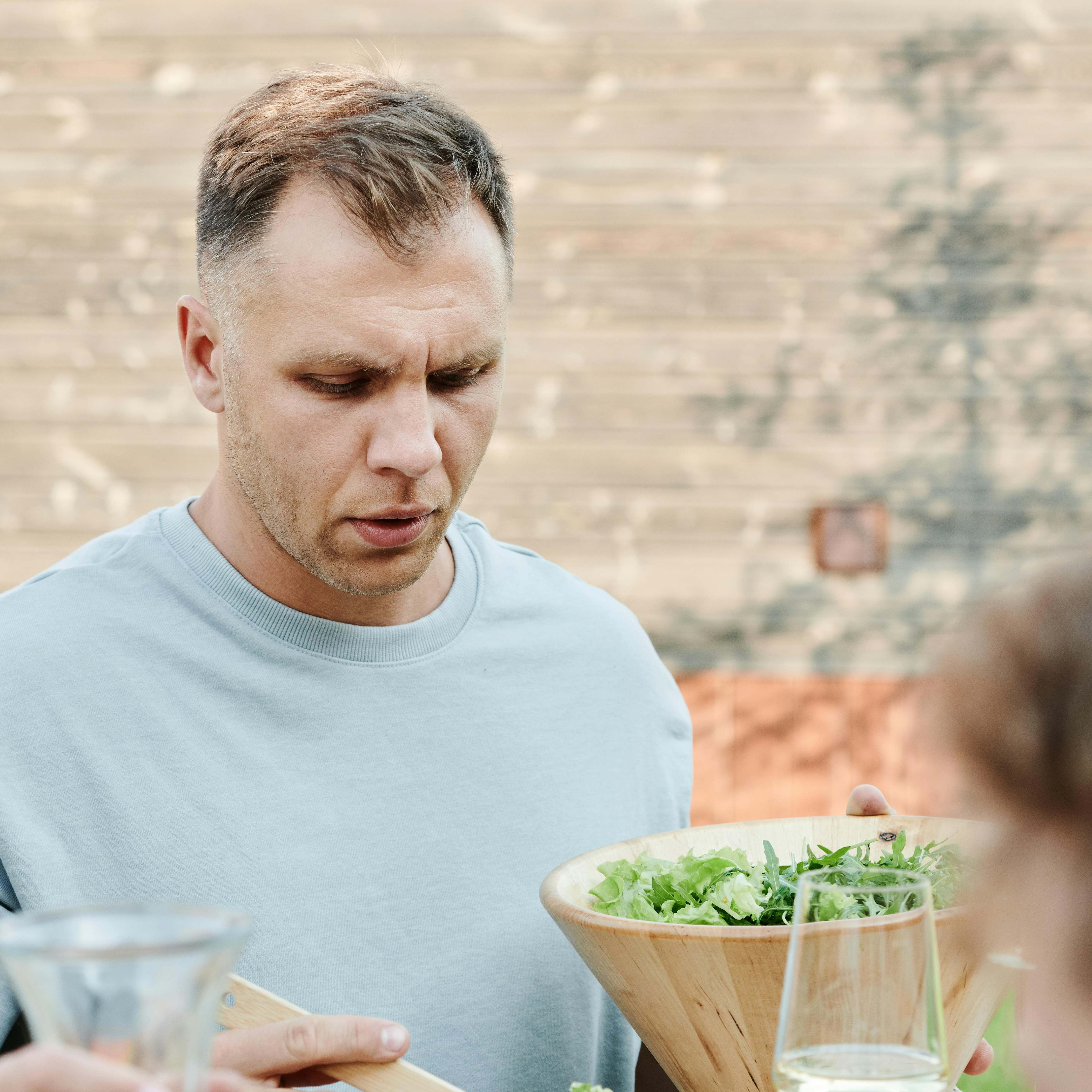 Ein Mann bedient sich aus einer Salatschüssel | Quelle: Pexels