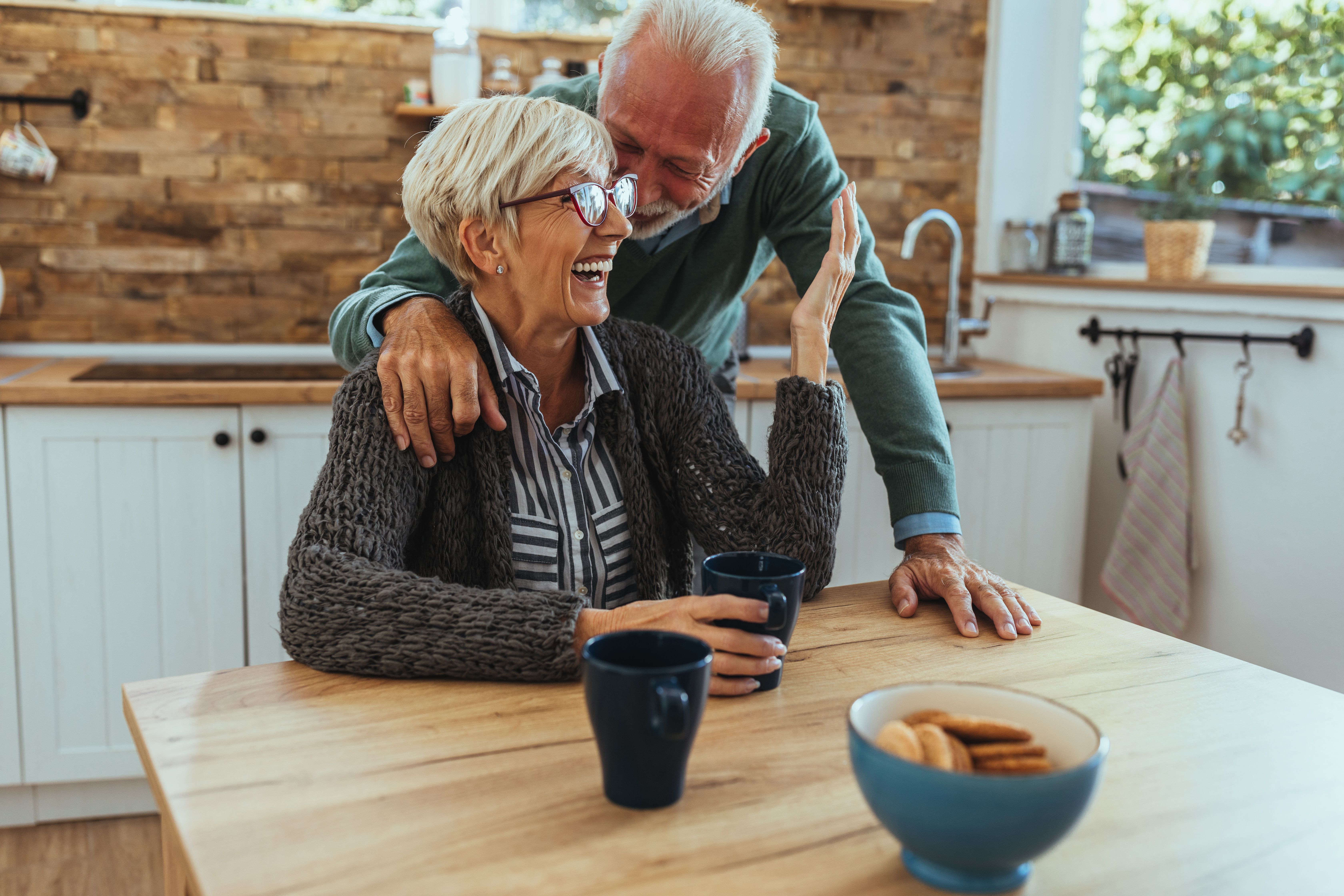 Ein älteres Paar lacht in der Küche. | Quelle: Shutterstock