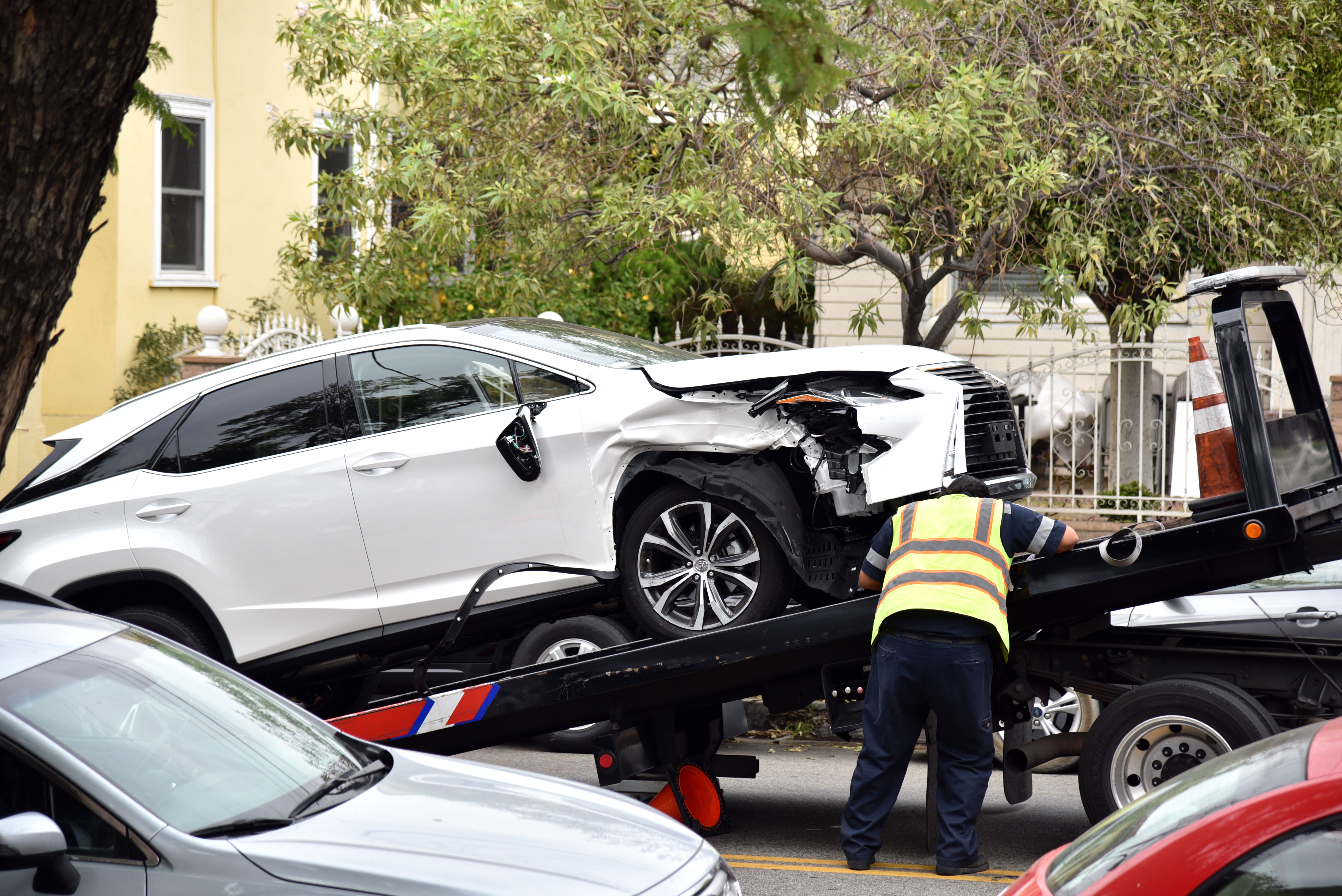 Ein Abschleppwagenfahrer schleppt ein beschädigtes Auto ab. | Quelle: Shutterstock