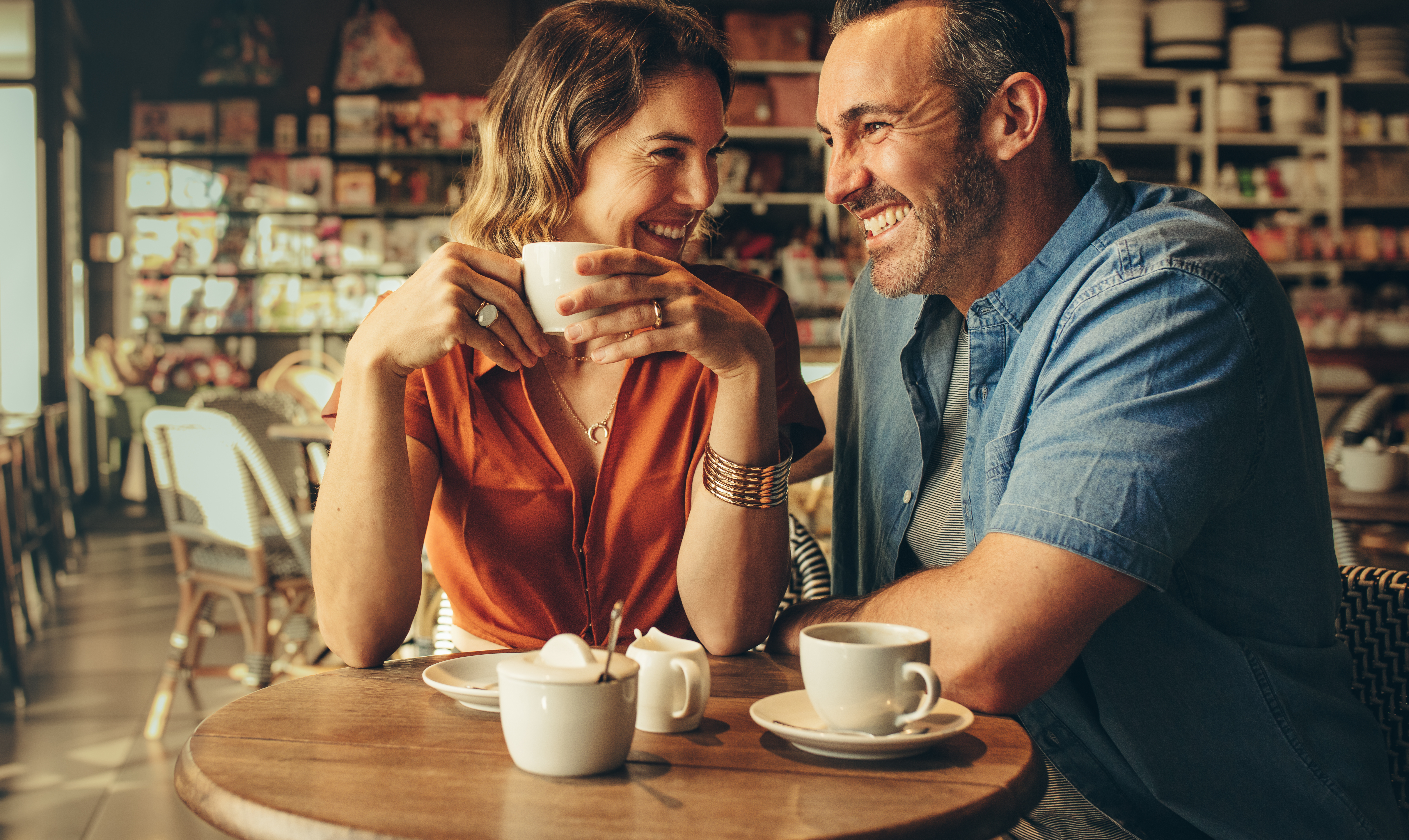 Ein glückliches Paar, das beim Kaffee lacht | Quelle: Shutterstock