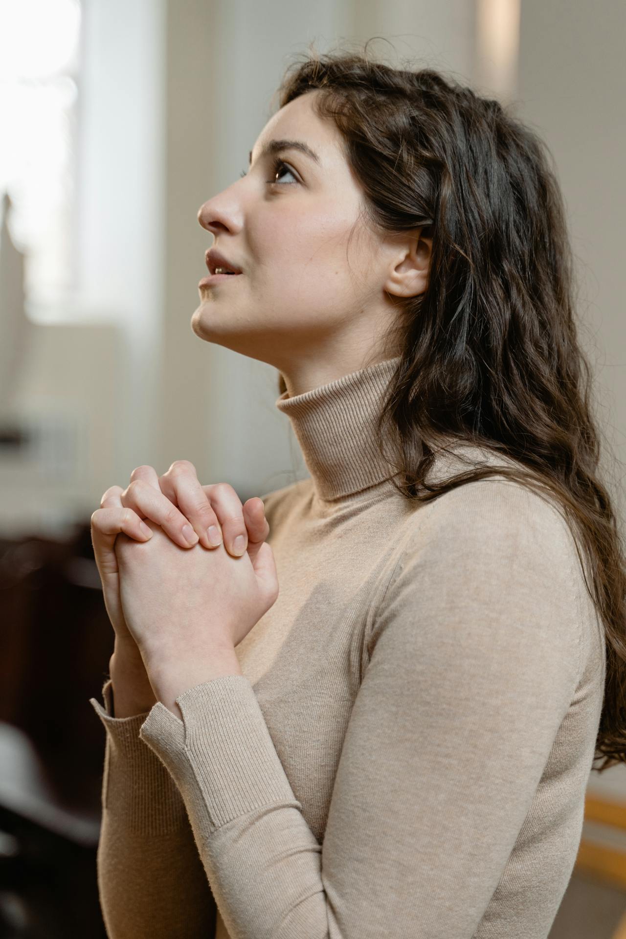 Eine verzweifelte junge Frau in einer Kirche | Quelle: Pexels