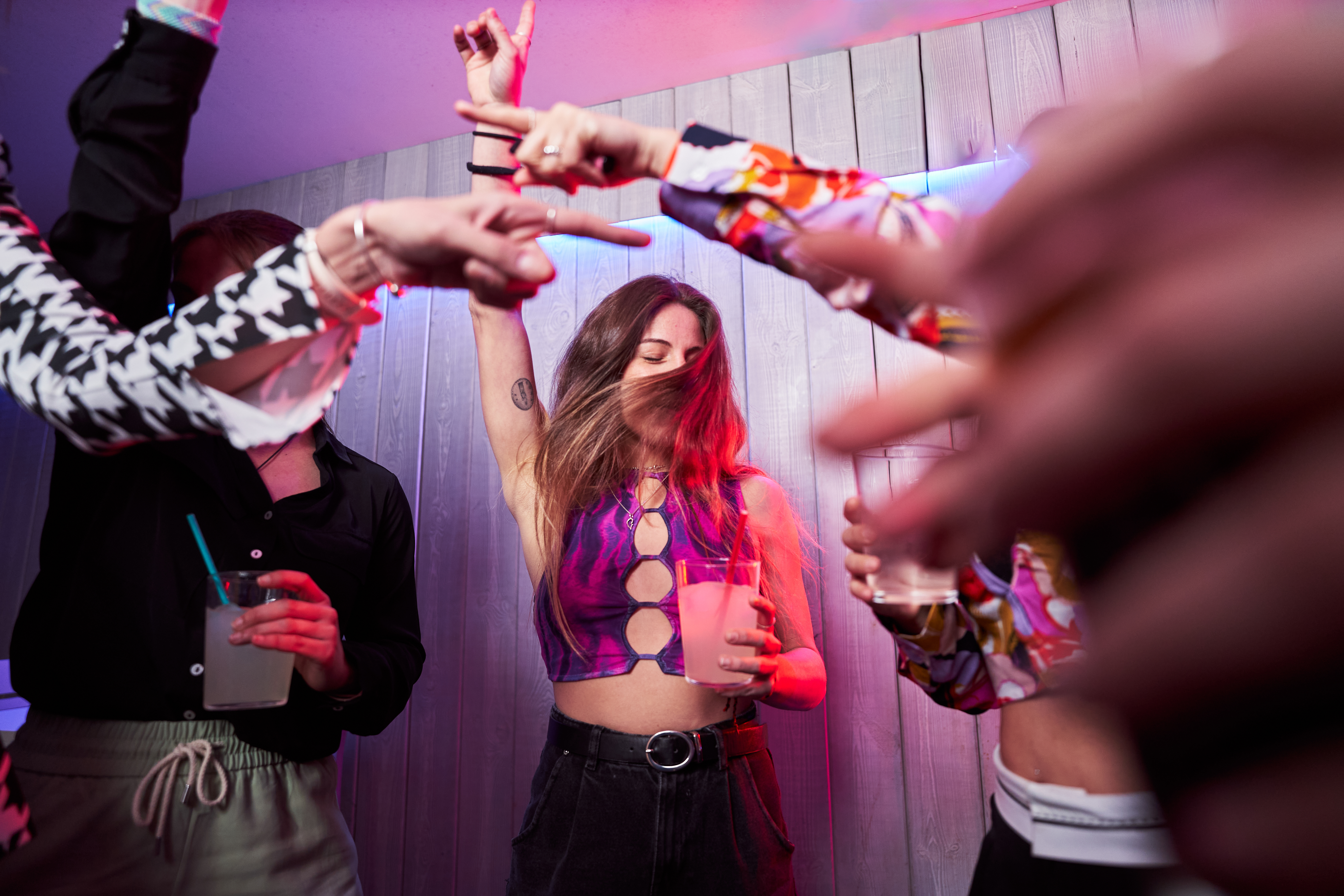 Glückliche Freunde tanzen zusammen in einem Nachtclub | Quelle: Getty Images