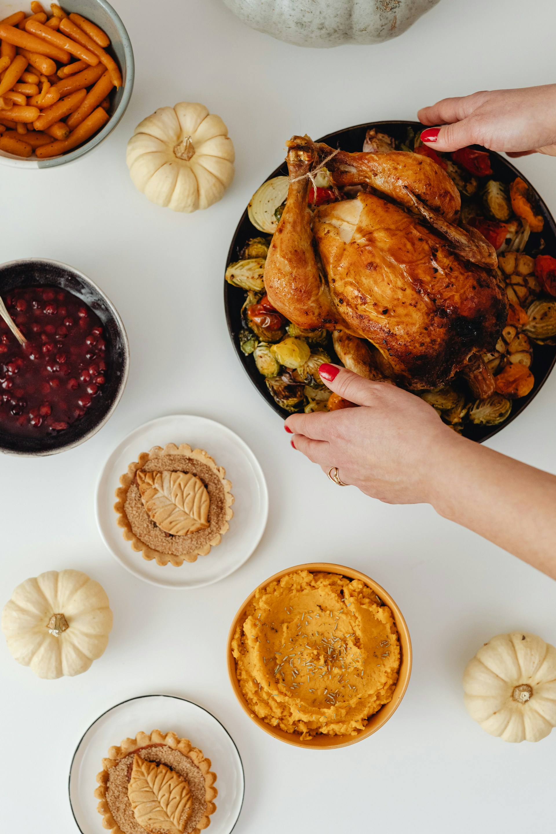 Eine Frau stellt einen Teller mit Hähnchenbraten auf den Tisch | Quelle: Unsplash