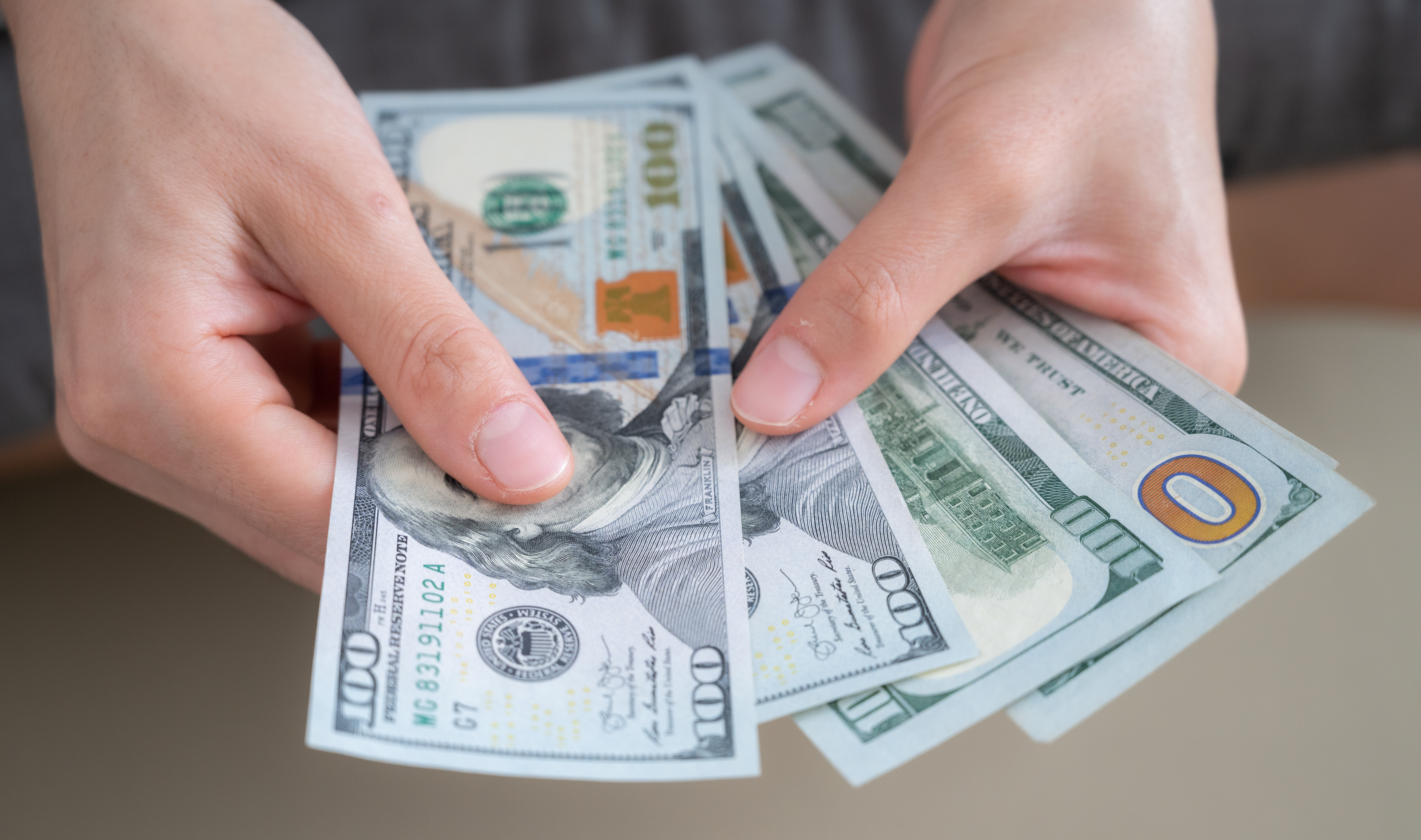 Hände, die amerikanische Dollar zählen | Quelle: Getty Images