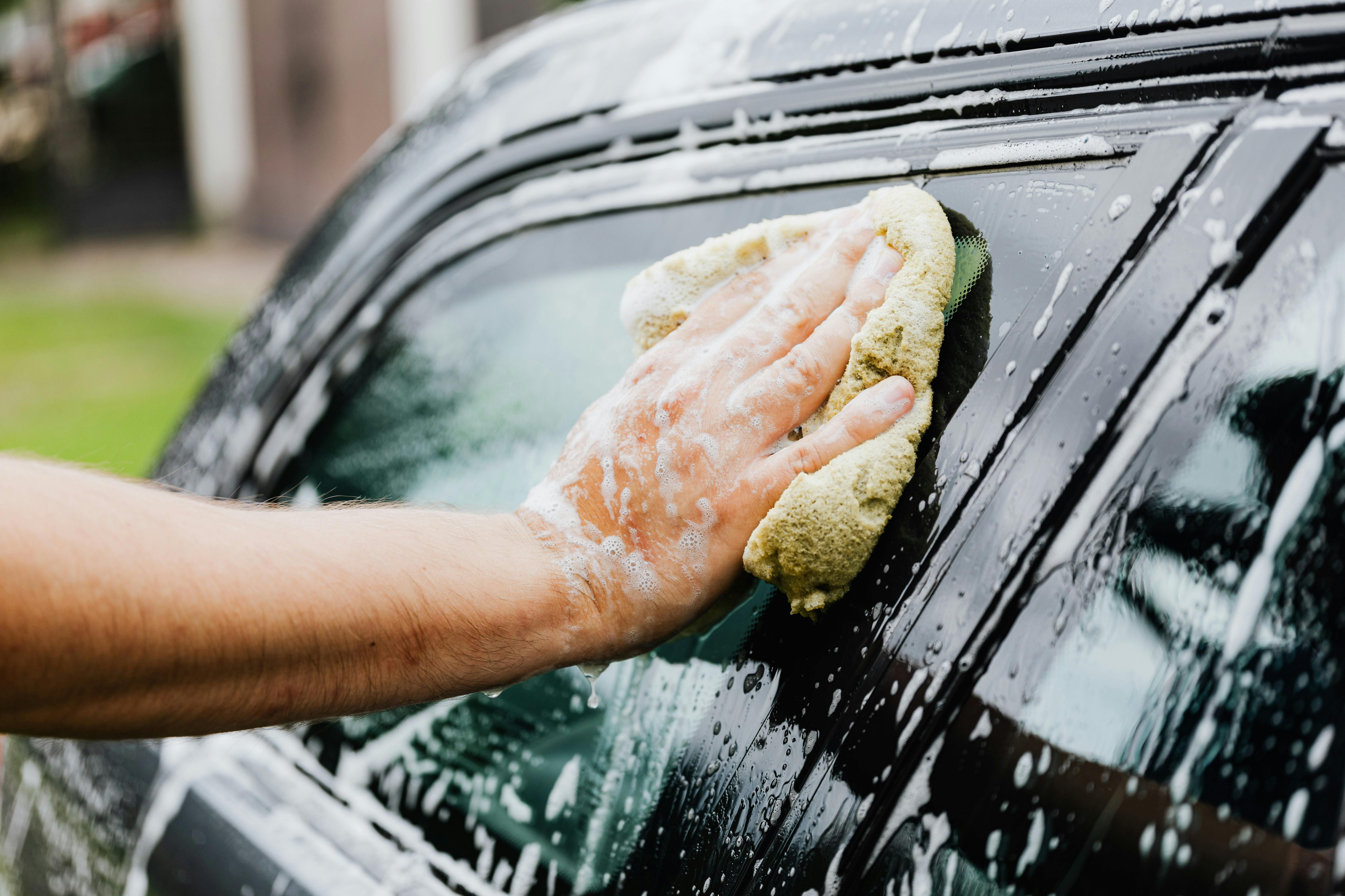 Ein Mann wäscht sein Auto | Quelle: Pexels