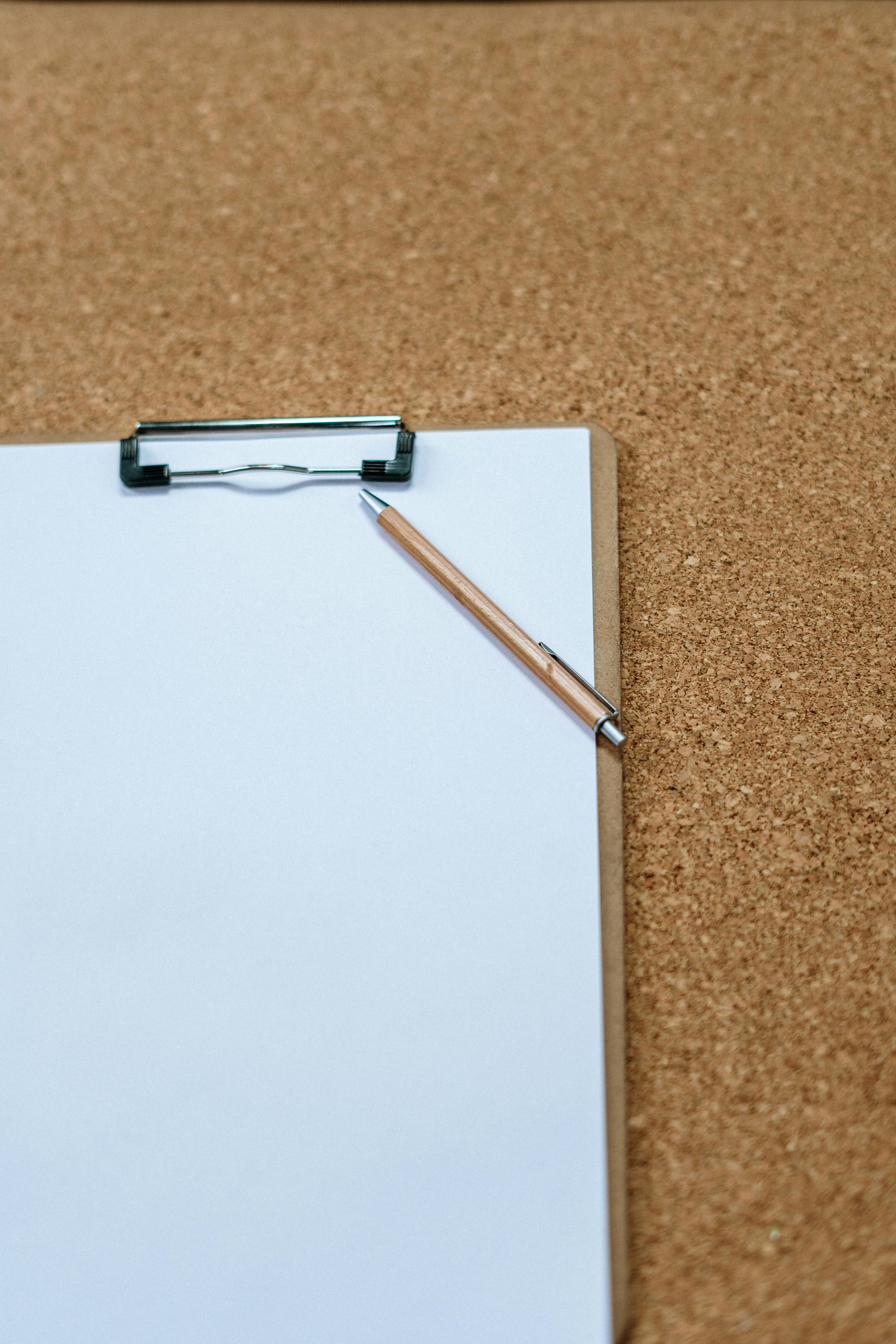 Papier und Stift auf einem braunen Teppich | Quelle: Pexels