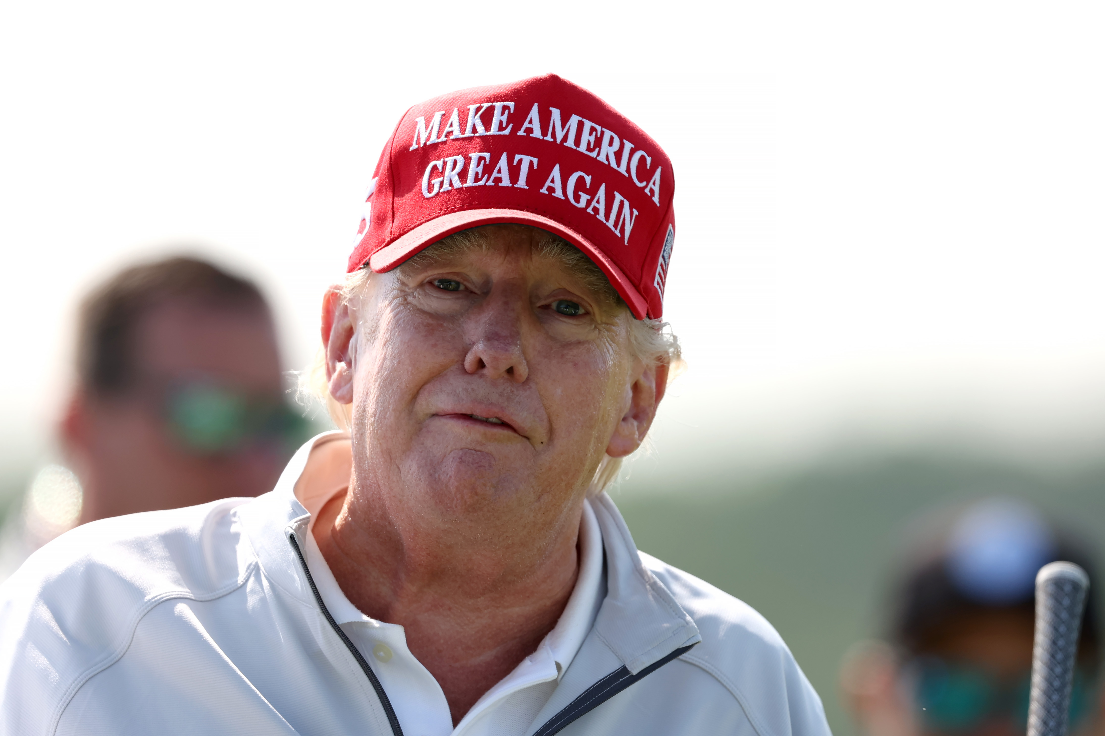Auf einer anderen Aufnahme vom selben Tag blickt Donald Trump mit einem ruhigen Gesichtsausdruck in die Kamera. Die Rottöne in seinem Gesicht sind besonders an den Wangen deutlich zu erkennen und stehen im Kontrast zu der blassen Haut in der Nähe seines Kragens.