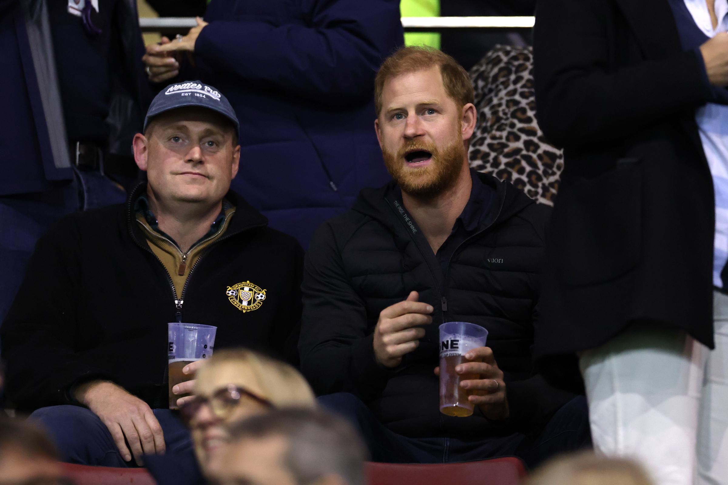 Prinz Harry beugt sich auf seinem Sitz nach vorne, während er sich am 9. Oktober 2026 in Leicester, England, das Gallagher-PREM-Spiel der Saison 2026/2027 zwischen den Leicester Tigers und Gloucester Rugby ansieht. Er hält einen Plastikbecher in der Hand, während die Zuschauer um ihn herum das Spiel verfolgen. | Quelle: Getty Images