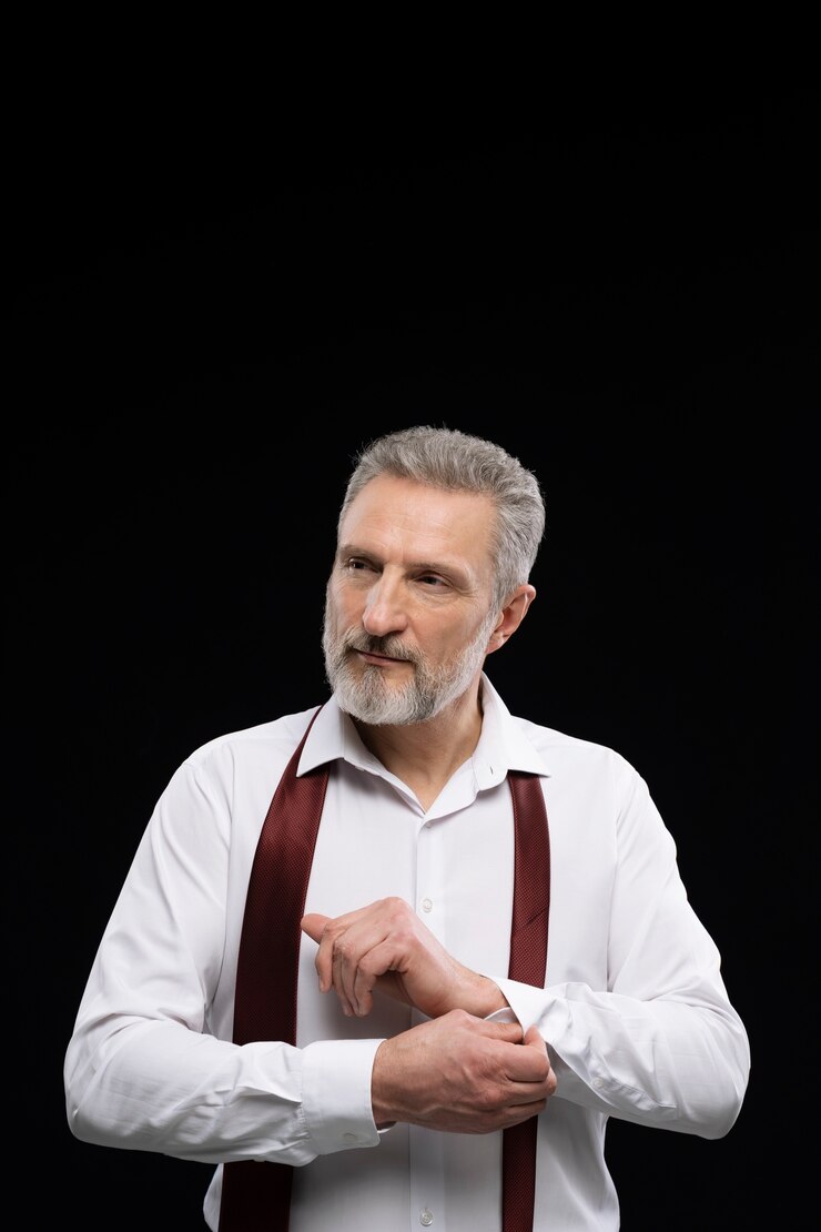 Ein lächelnder reifer Mann, der zur Seite schaut | Quelle: Freepik