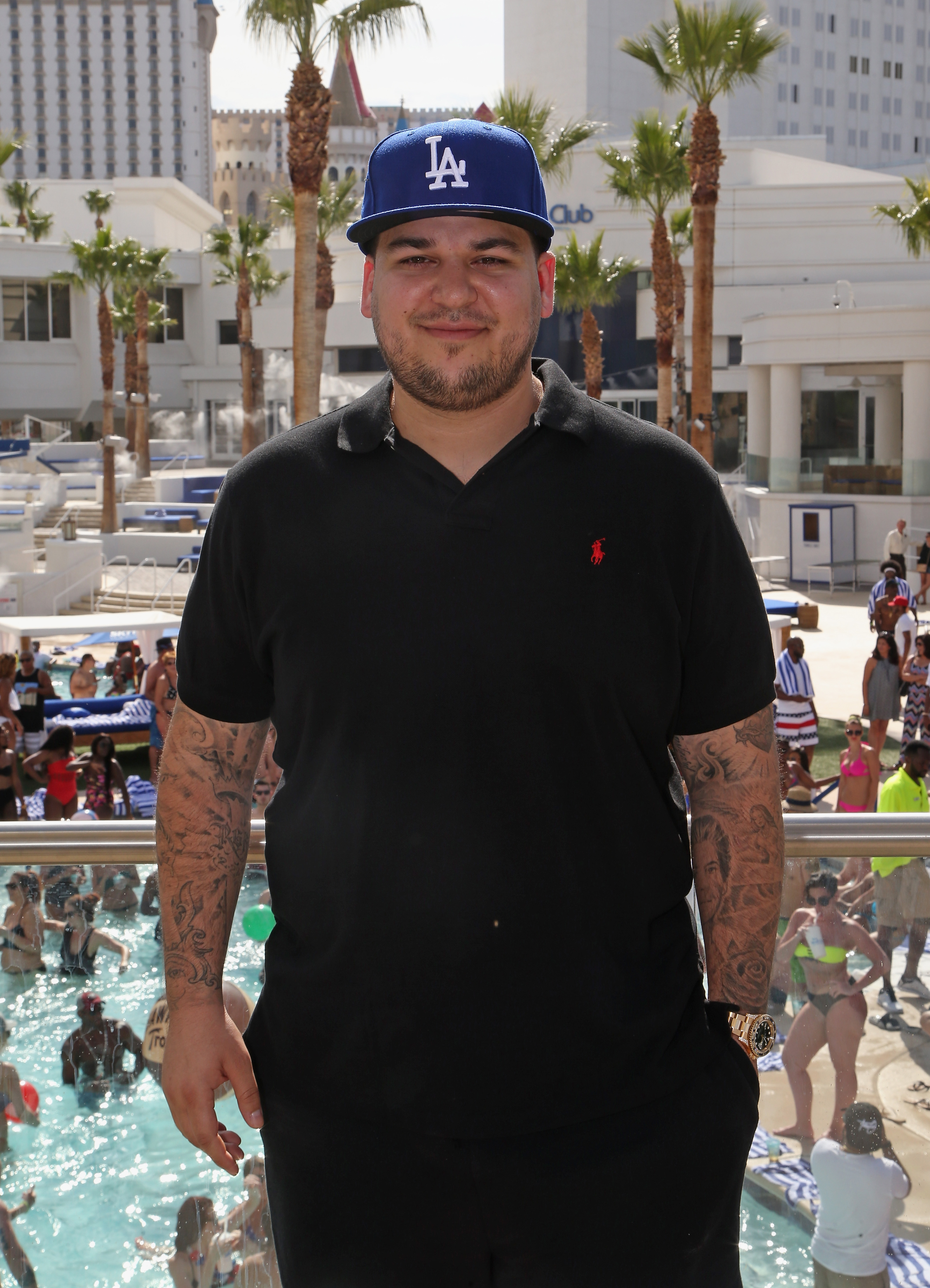 Rob Kardashian posiert im Mai 2016 im Sky Beach Club in Las Vegas in einem schwarzen Polohemd und einer LA-Baseballkappe. Dieser Auftritt war einer seiner seltenen Auftritte in der Öffentlichkeit, nachdem er jahrelang mit seinem Körperbild zu kämpfen hatte und Kameras mied. | Quelle: Getty Images.