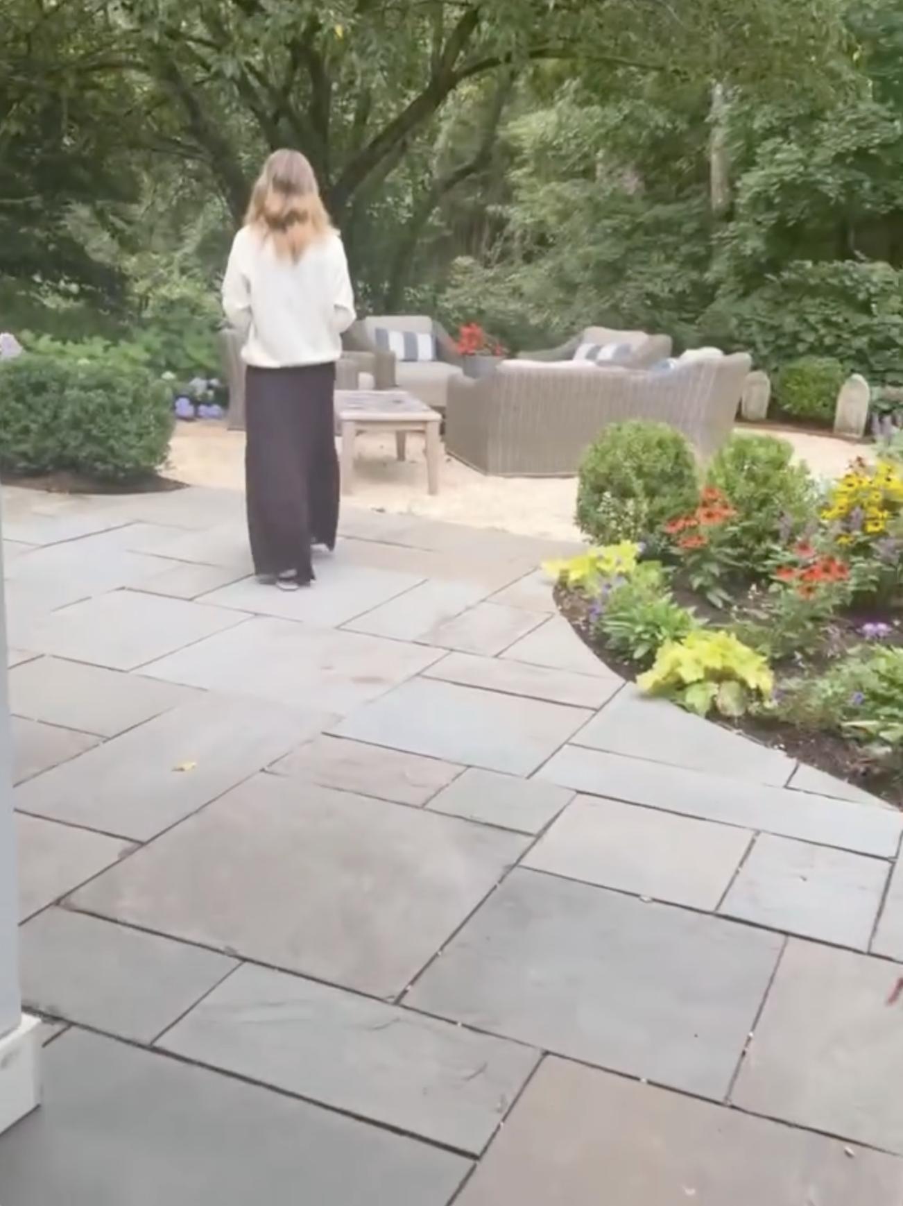 Eine Terrassenlounge, umgeben von altem Baumbestand, bunten Blumenbeeten und gepflegten Grünflächen, bietet einen ruhigen Rückzugsort im Freien auf dem Grundstück. | Quelle: Instagram/alejandragere