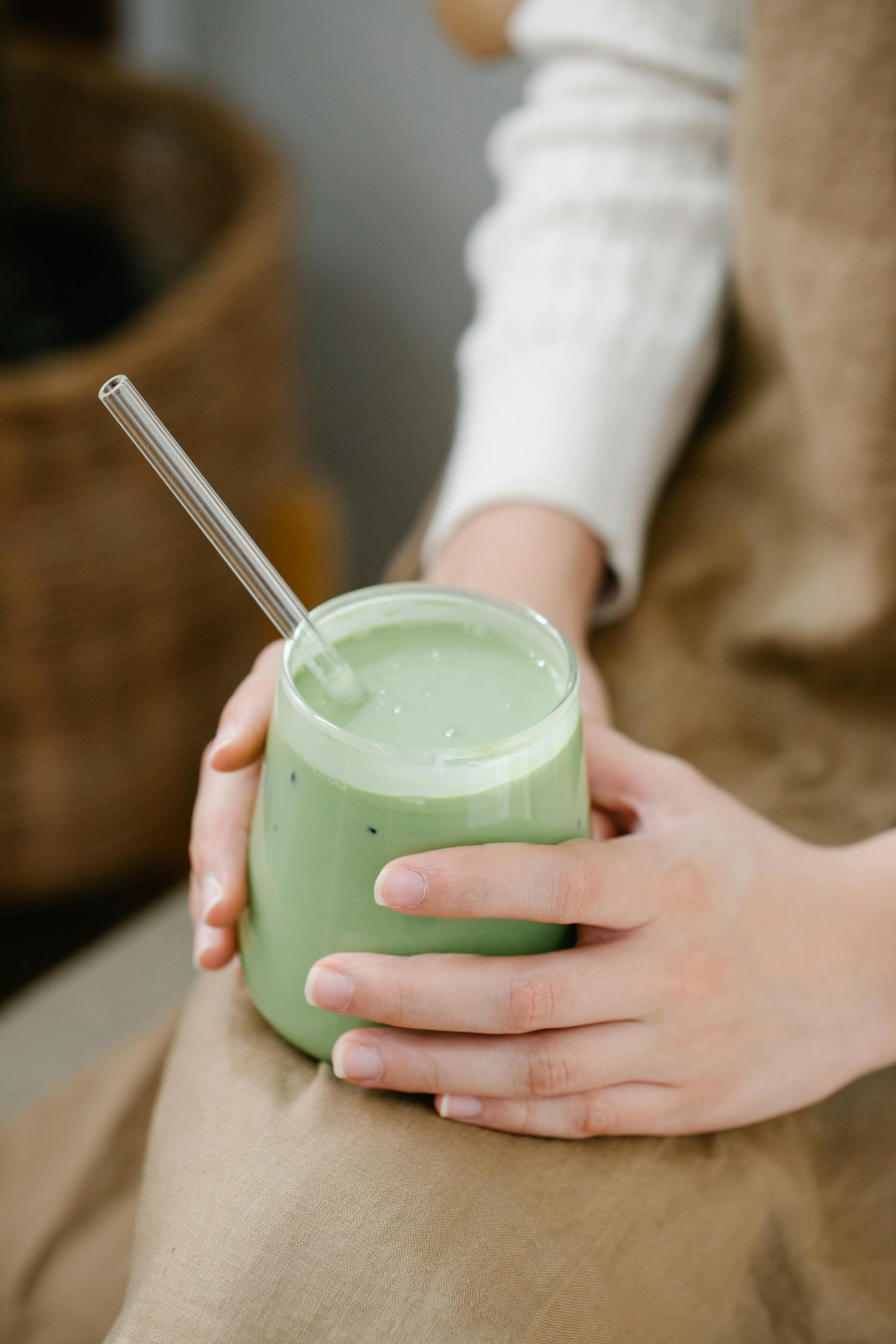 Eine Frau mit einem grünen Smoothie in der Hand | Quelle: Pexels