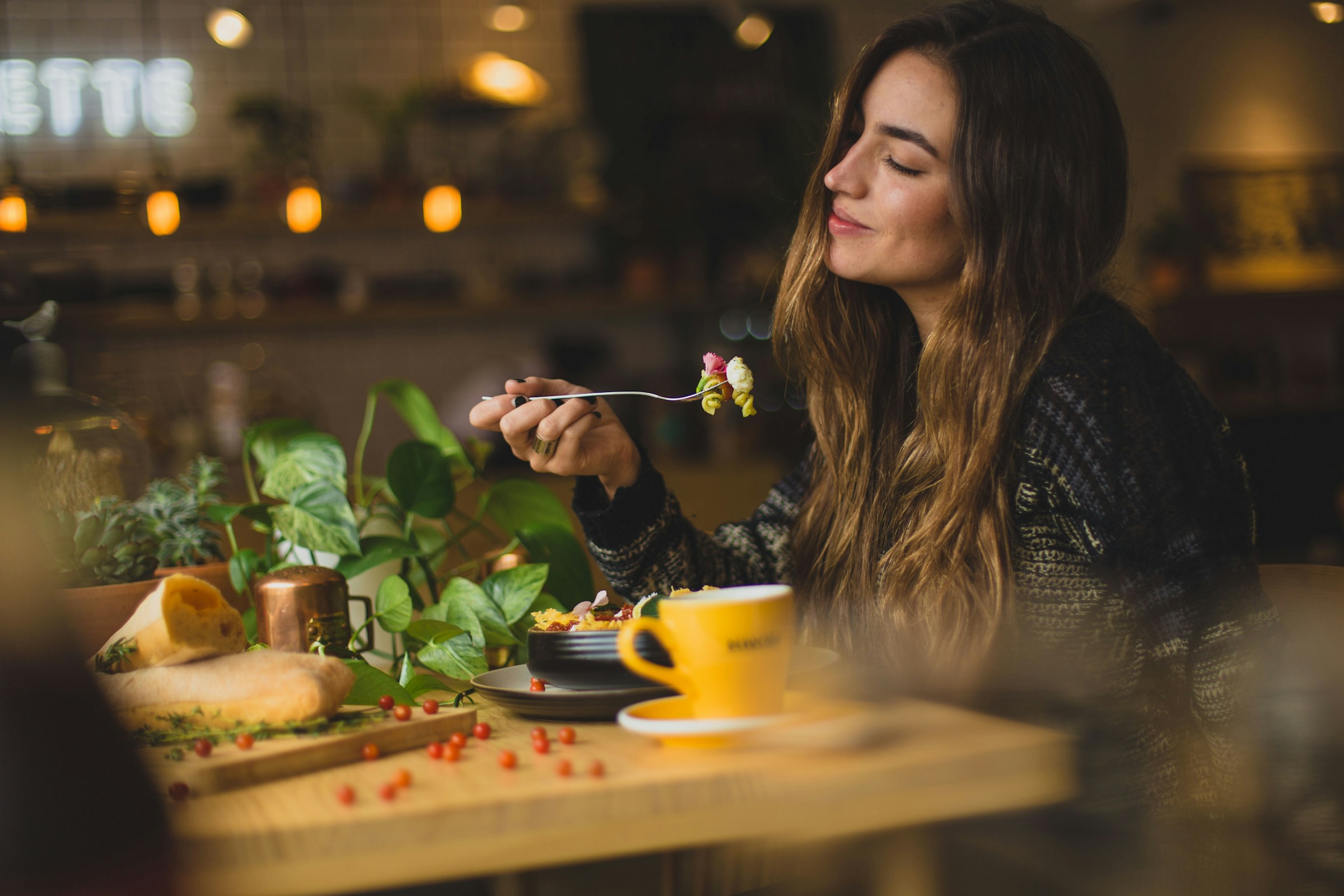 Eine Frau genießt das Abendessen in einem Restaurant | Quelle: Unsplash