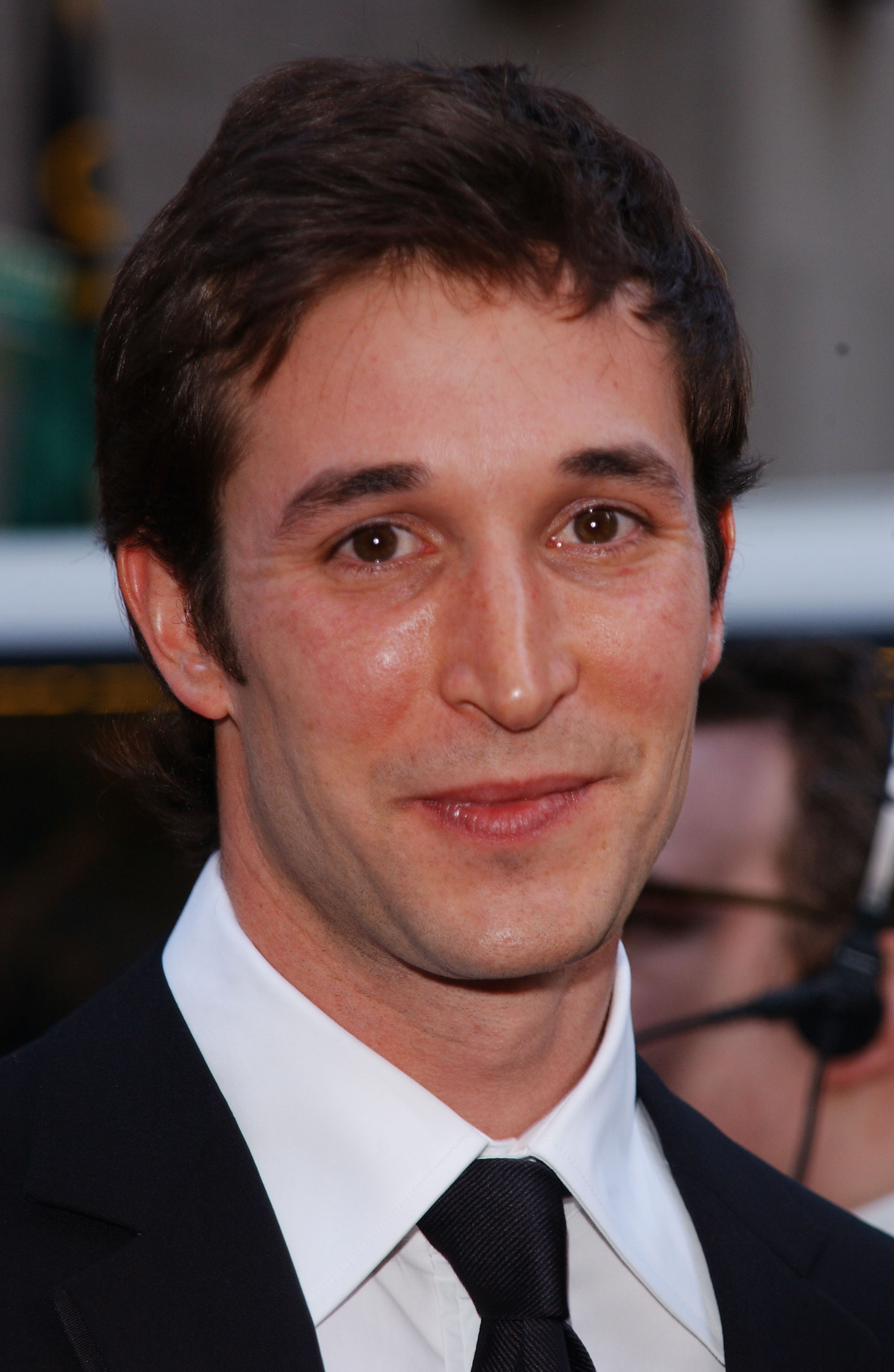 Noah Wyle bei einem Red-Carpet-Event in seinen jüngeren Jahren, gekleidet in einen klassischen schwarzen Anzug, ein weißes Hemd und eine Krawatte. | Quelle: Getty Images
