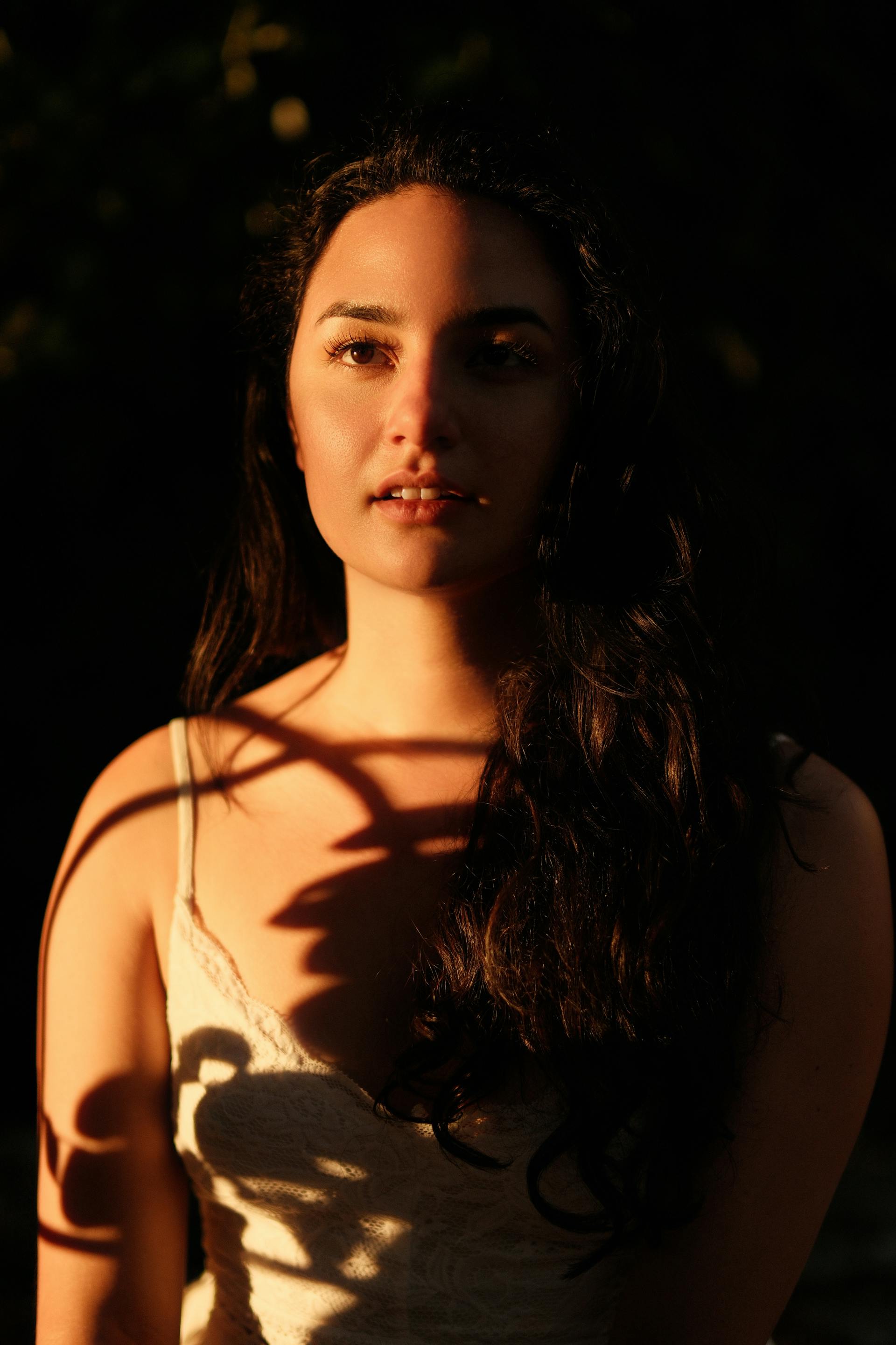 Das Porträt einer jungen Frau mit Schatten, die auf ihren Körper fallen | Quelle: Pexels