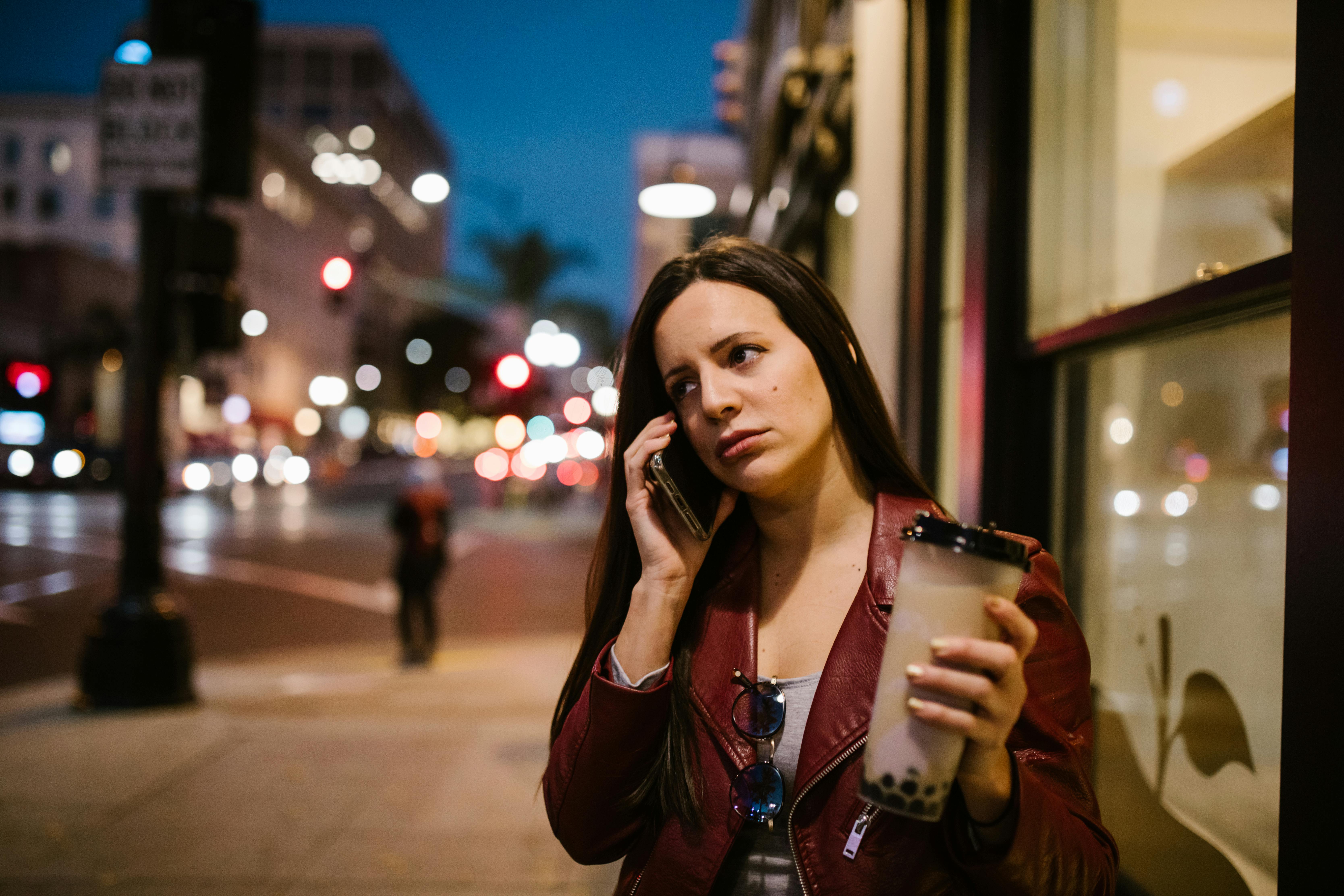 Eine telefonierende Frau auf einem Bürgersteig | Quelle: Pexels