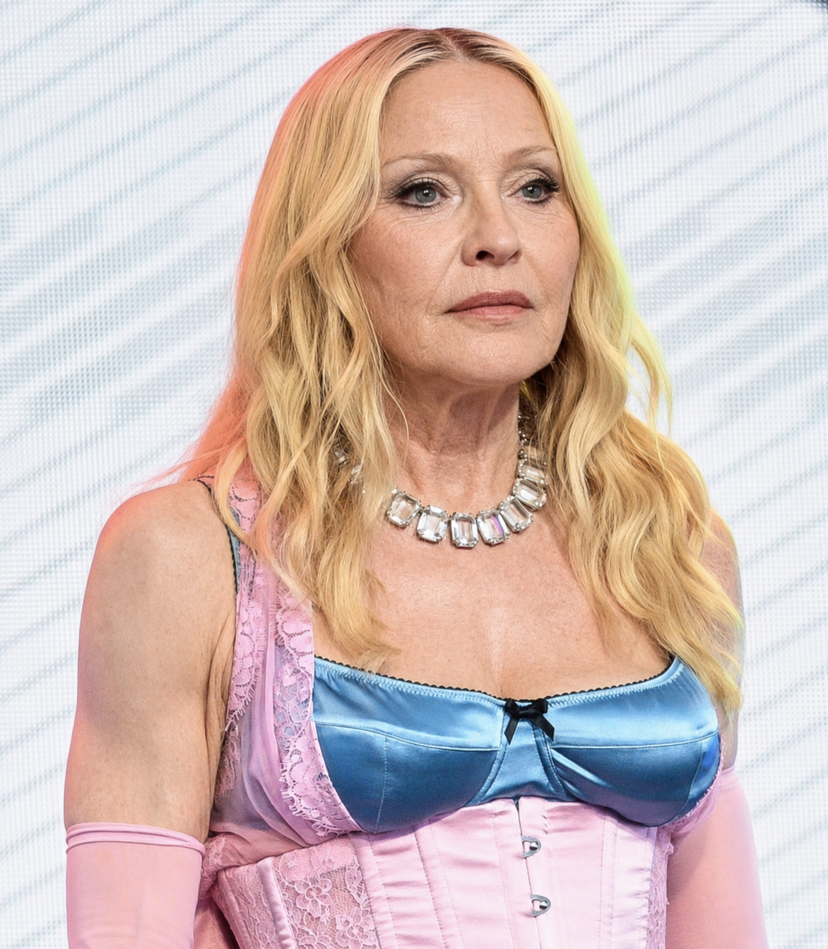 Auf dem digital bearbeiteten Bild sind Madonnas farbenfrohes Outfit und ihre blonde Frisur erhalten geblieben, während ihr Gesicht, ihr Hals und ihr oberer Brustbereich deutlichere Altersspuren aufweisen. | Quelle: Chat GPT