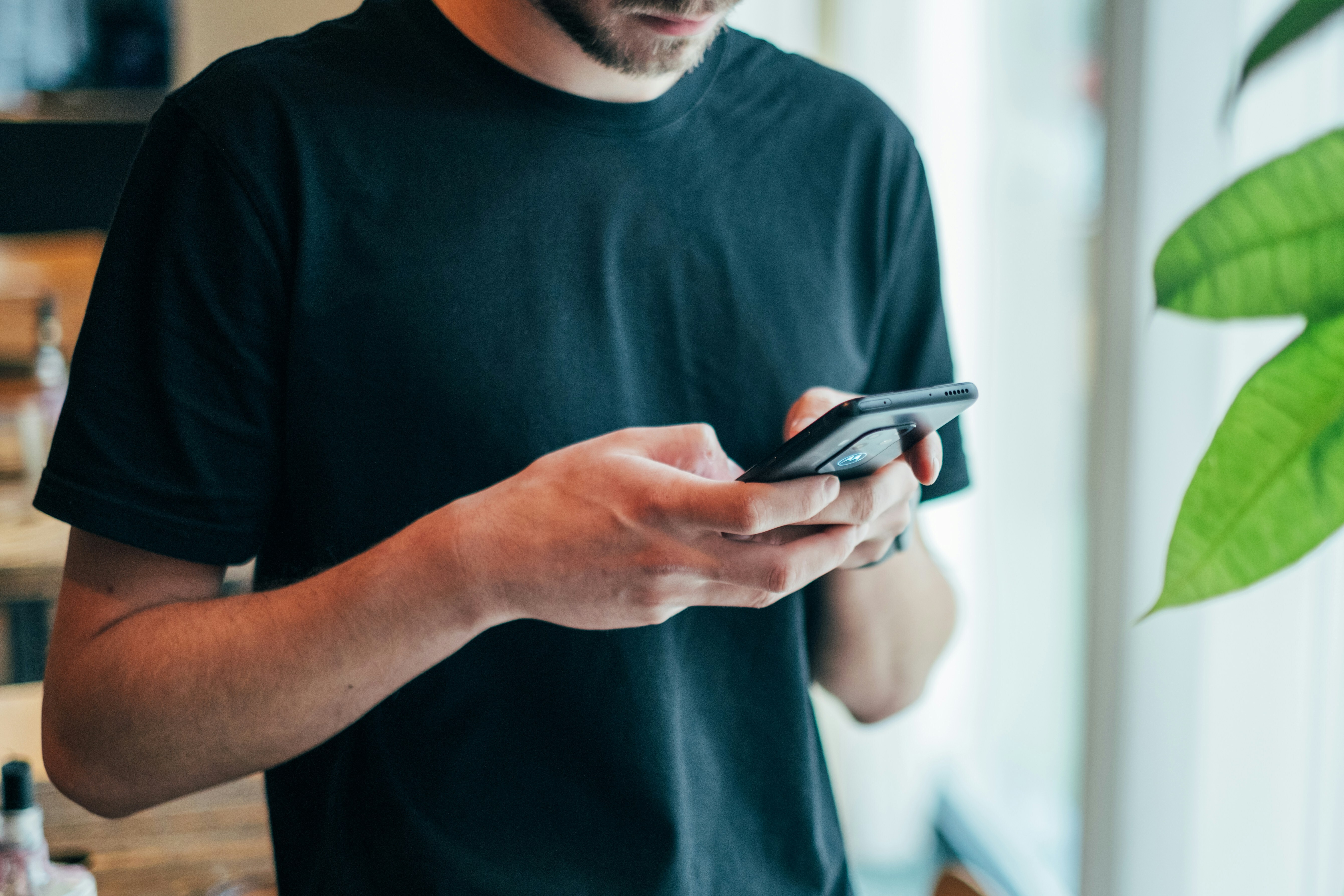 Mann schreibt eine SMS auf seinem Handy | Quelle: Unsplash