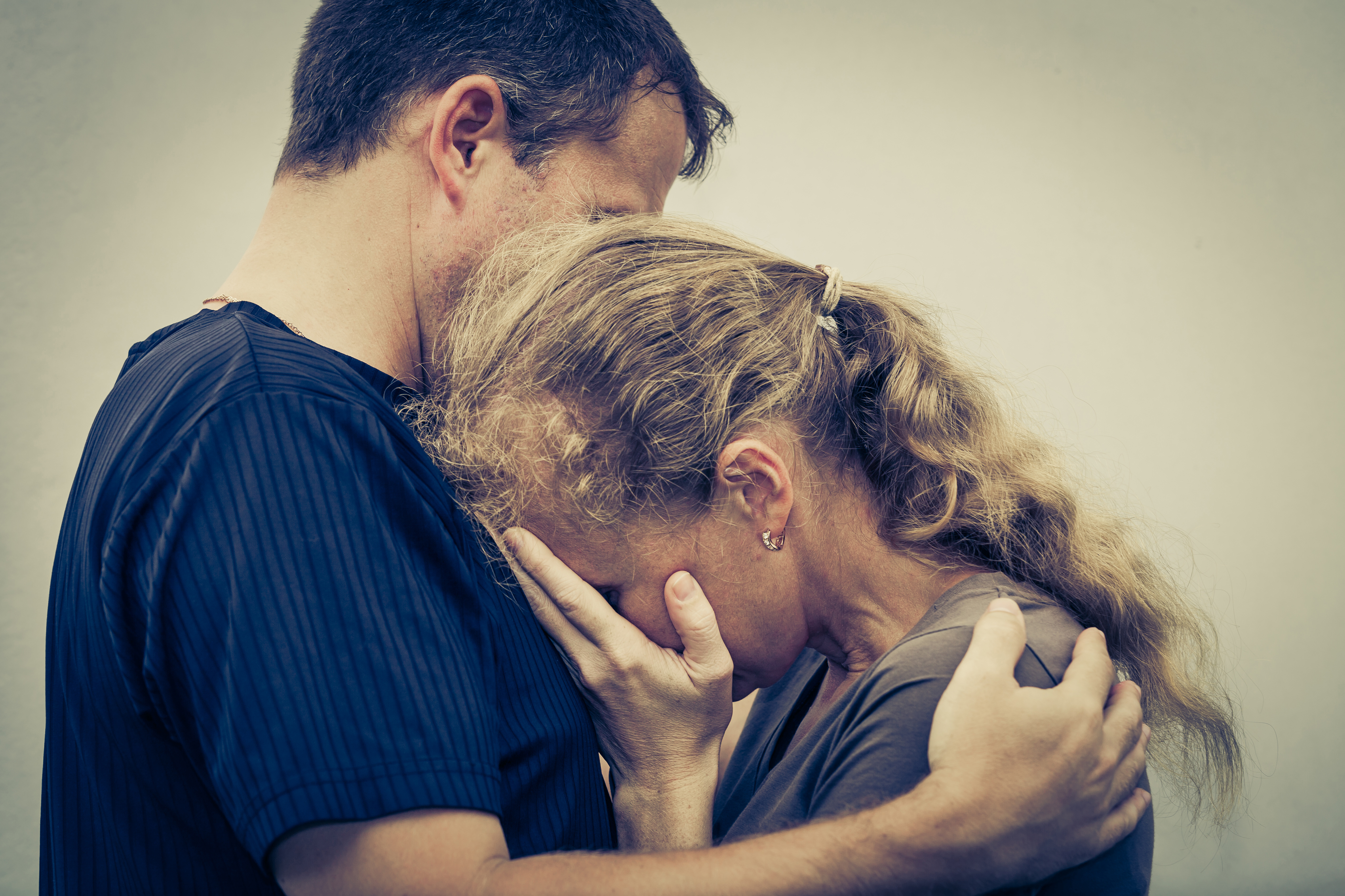 Eine weinende Frau, die ihren Mann umarmt | Quelle: Shutterstock