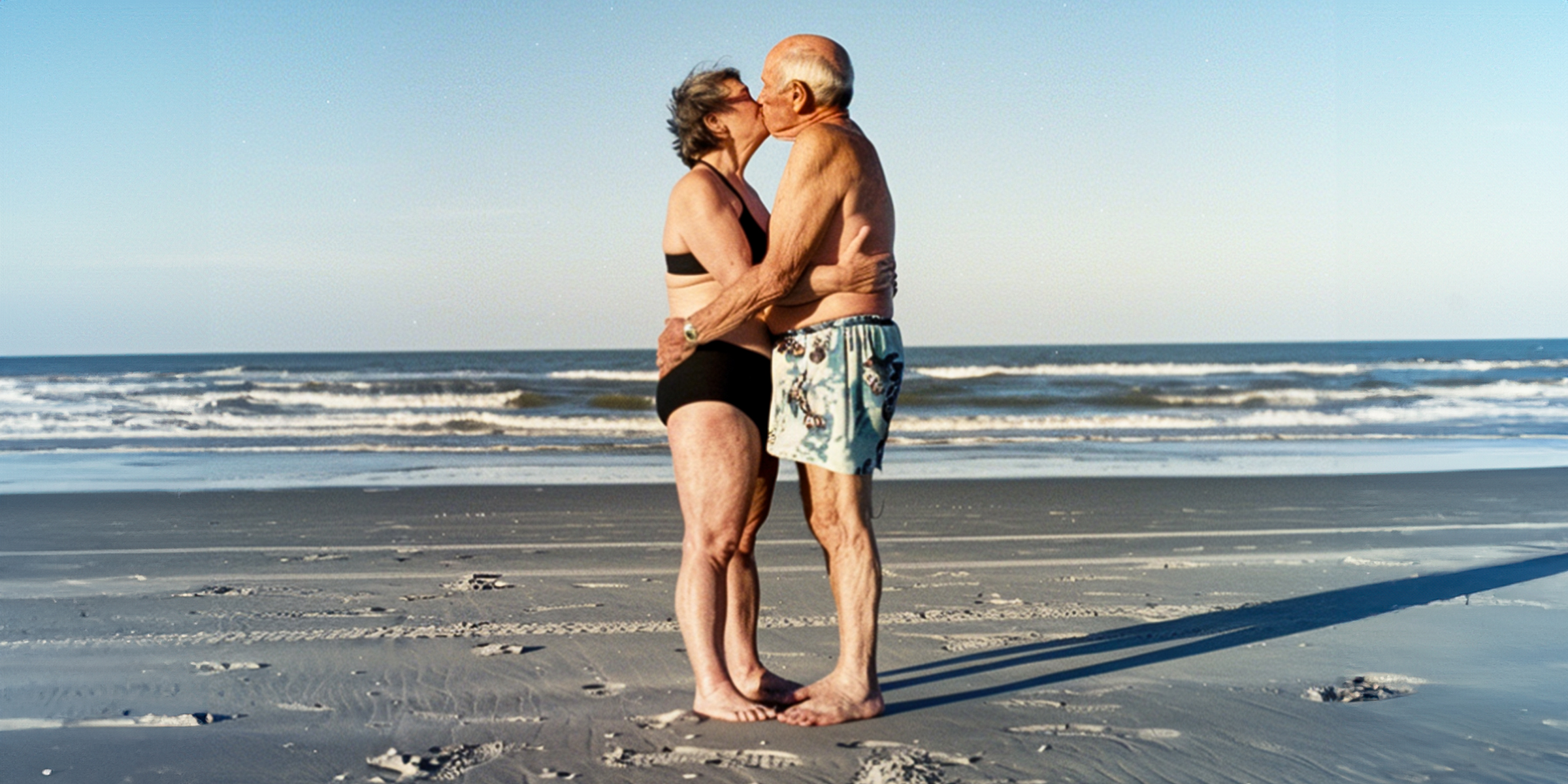 Ein älteres Paar, das sich am Strand küsst | Quelle: AmoMama