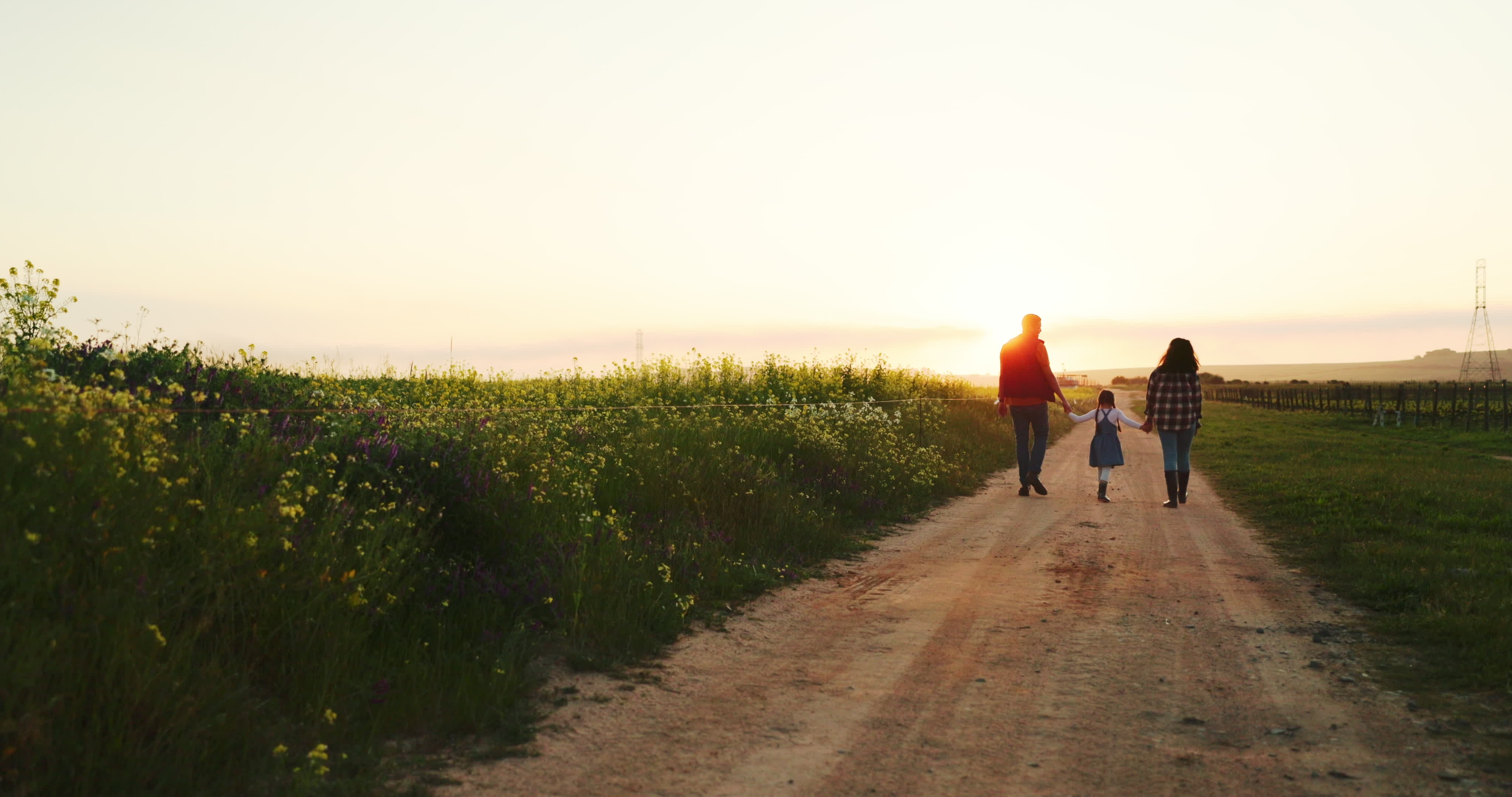 Eine dreiköpfige Familie genießt einen Spaziergang auf ihrem Bauernhof | Quelle: Shutterstock