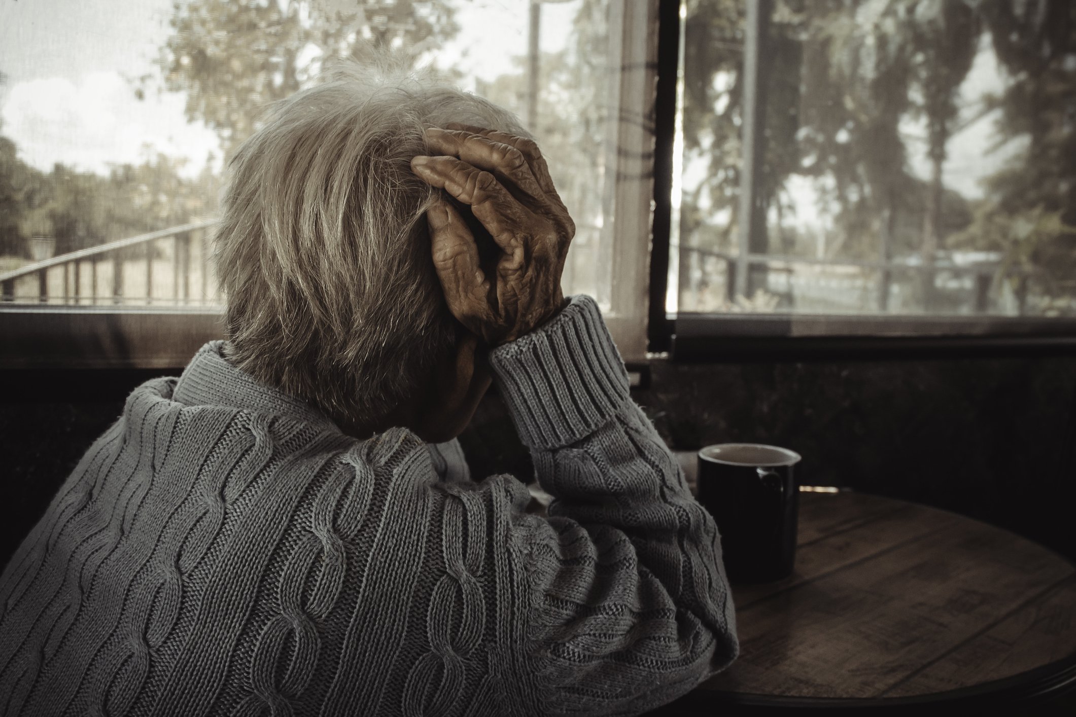 Die ältere Frau schaut durch ein Fenster. I Quelle: Getty Images