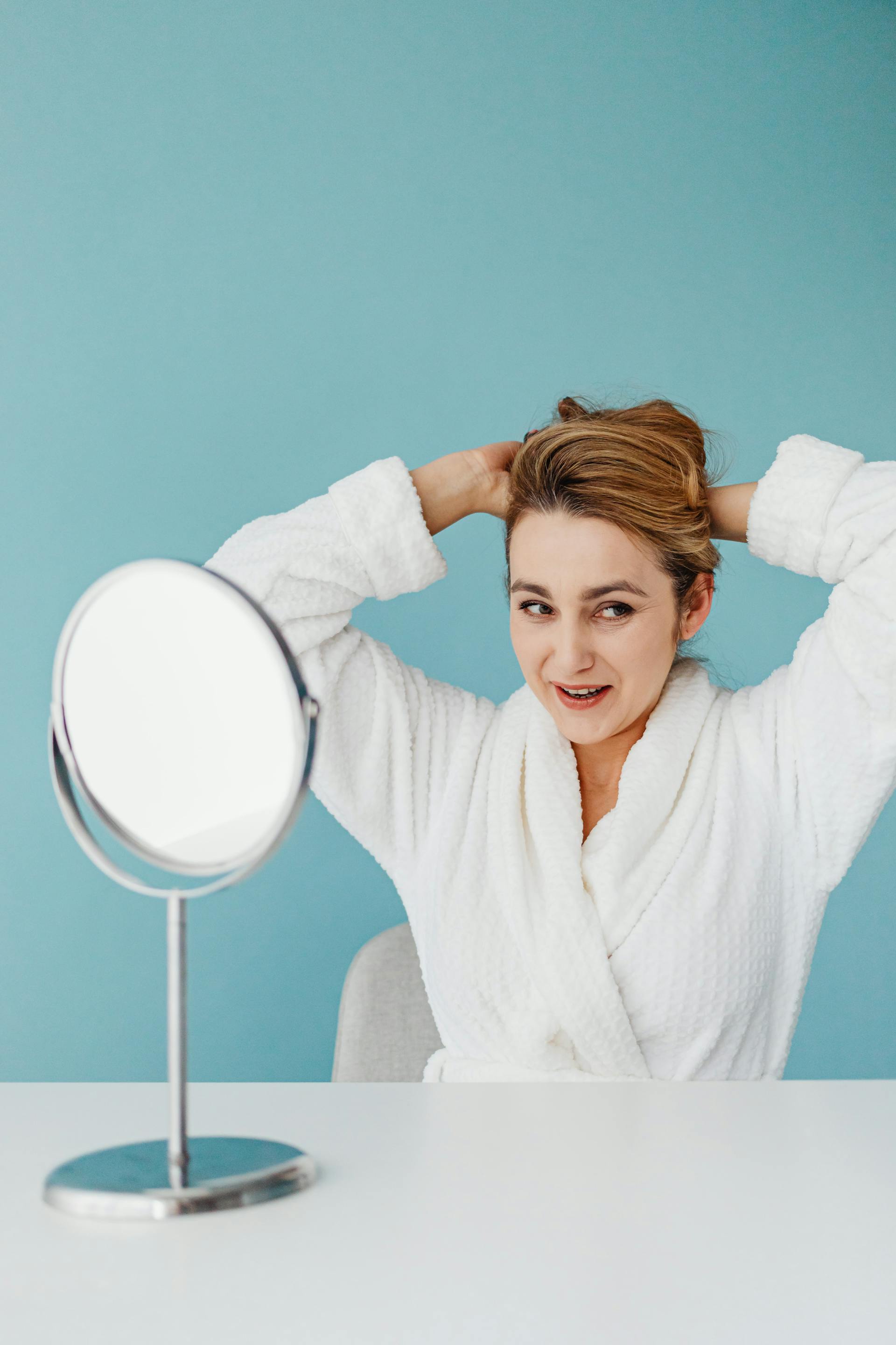 Eine lächelnde Frau, die sich die Haare macht | Quelle: Pexels