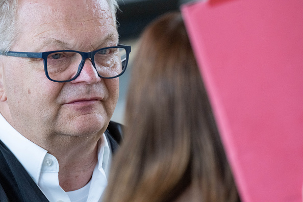 Die Angeklagte hält einen Ordner vor ihr Gesicht neben ihrem Anwalt Thomas Löcker im Gerichtssaal des Landgerichts Rostock, 18. Juni 2026. | Quelle: Getty Images