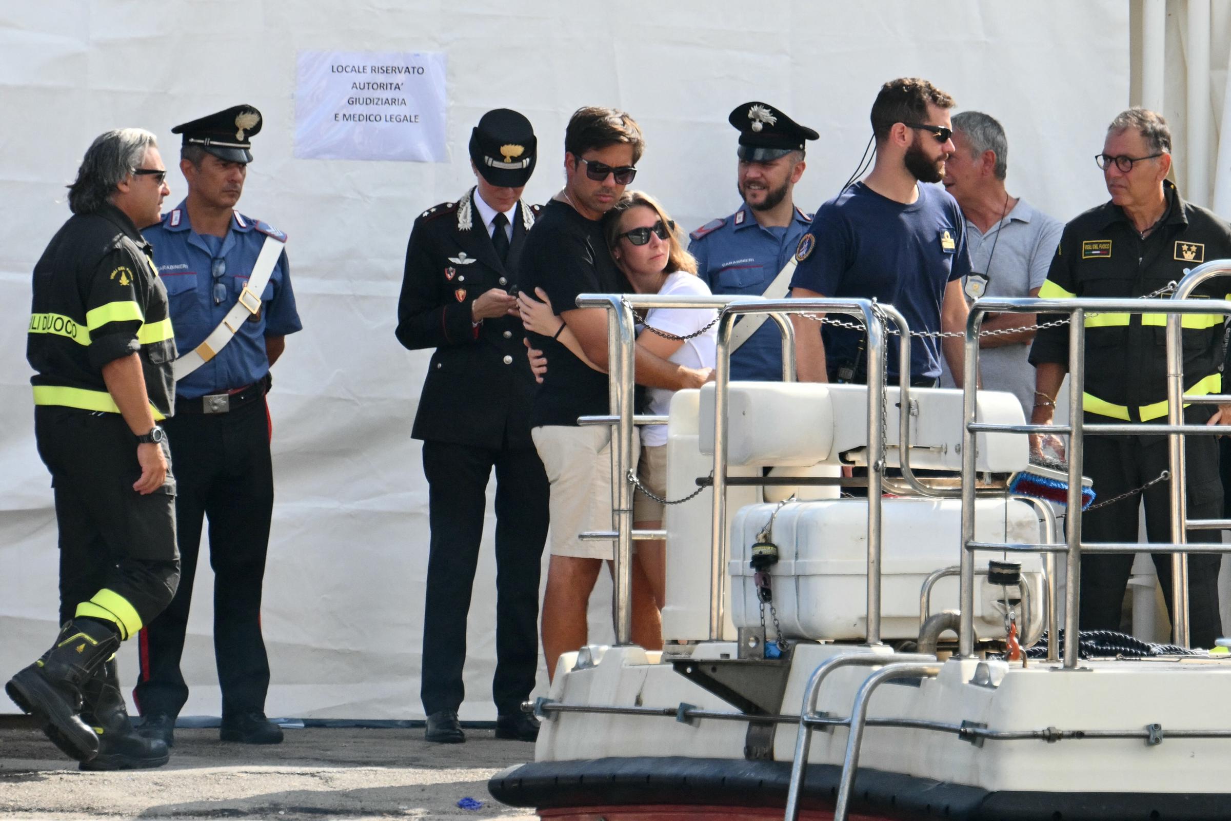 Menschen umarmen sich, als sie am 22. August 2024, drei Tage nach dem Untergang der unter britischer Flagge fahrenden Luxusyacht Bayesian, den Einsatz eines Such- und Rettungsteams am Pier von Porticello, Italien, beobachten. | Quelle: Getty Images