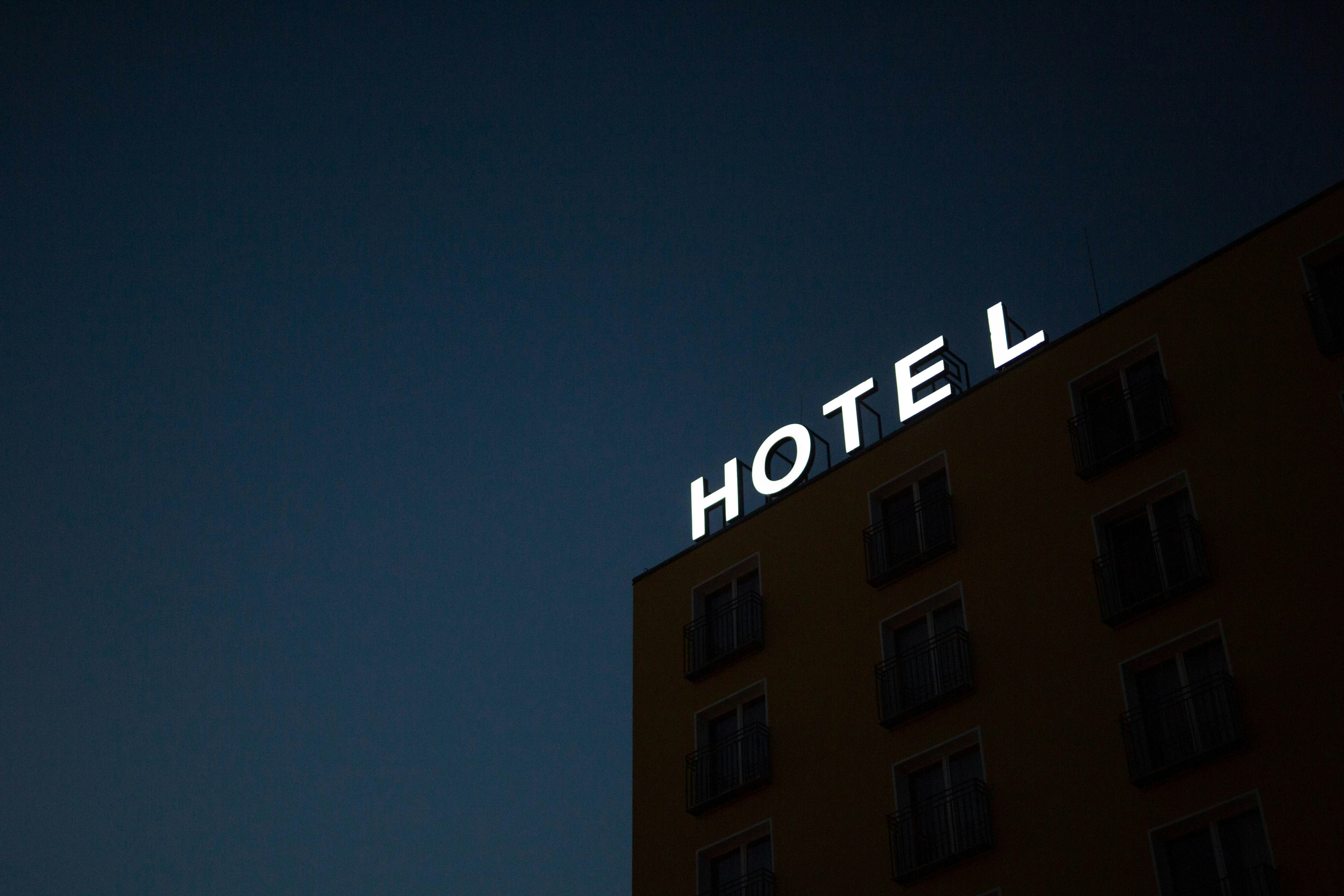 Eine Leuchtreklame mit der Aufschrift "HOTEL" an der Spitze eines Gebäudes | Quelle: Unsplash