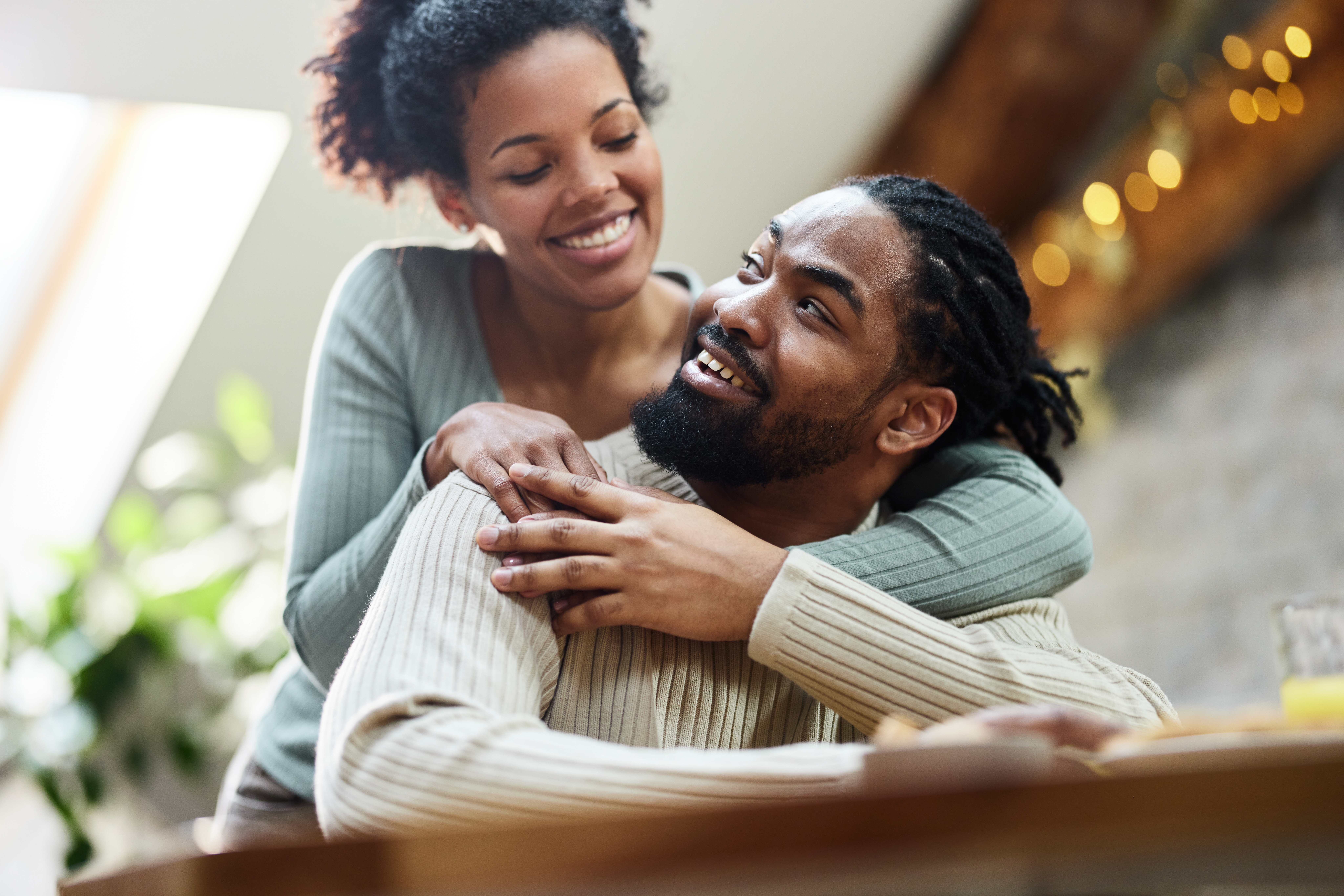 Ein glückliches schwarzes Paar unterhält sich am Morgen zu Hause | Quelle: Getty Images