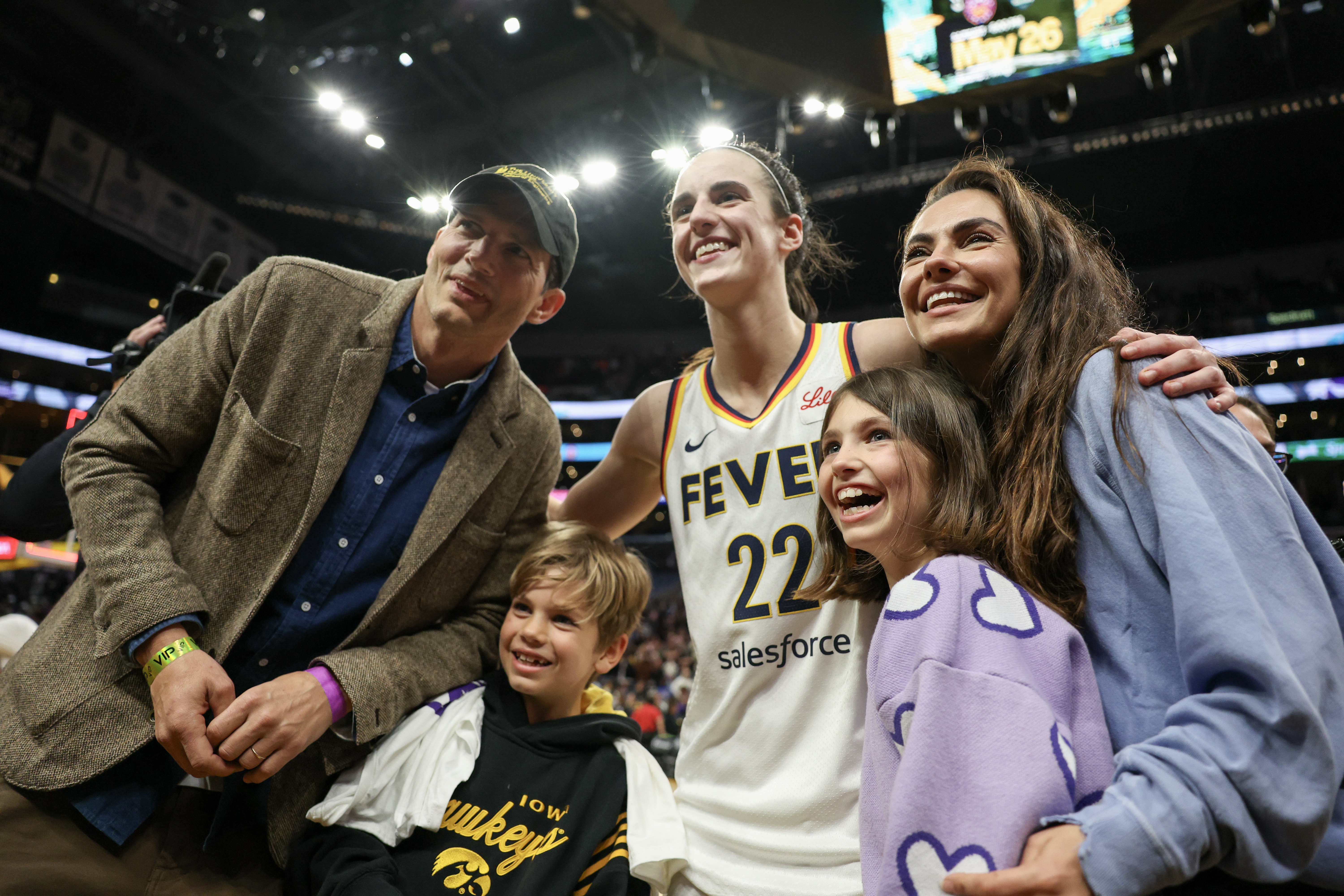 Ashton Kutcher, Mila Kunis und ihre Kinder posieren mit Caitlin Clark #22 von den Indiana Fever am 24. Mai 2024 | Quelle: Getty Images