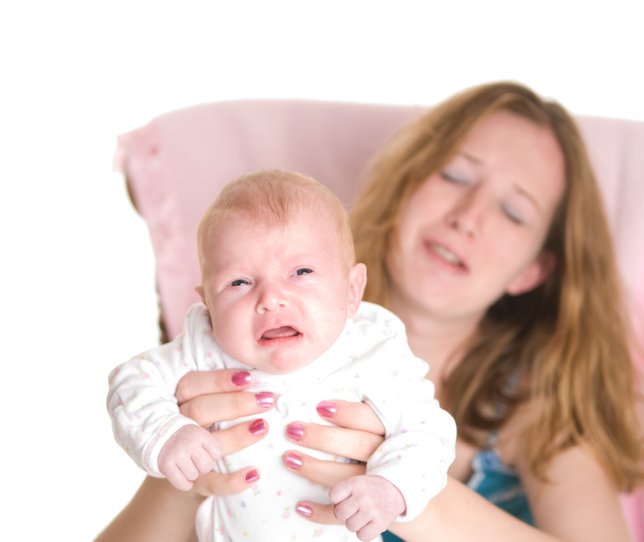 Frustrierte jugendliche Mutter, die versucht, weinendes Baby weiterzugeben. I Quelle: Getty Images