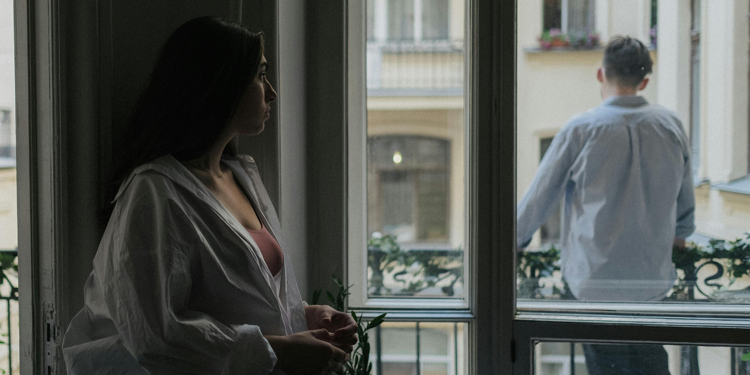 Frau beobachtet einen Mann auf einem Balkon | Quelle: Pexels