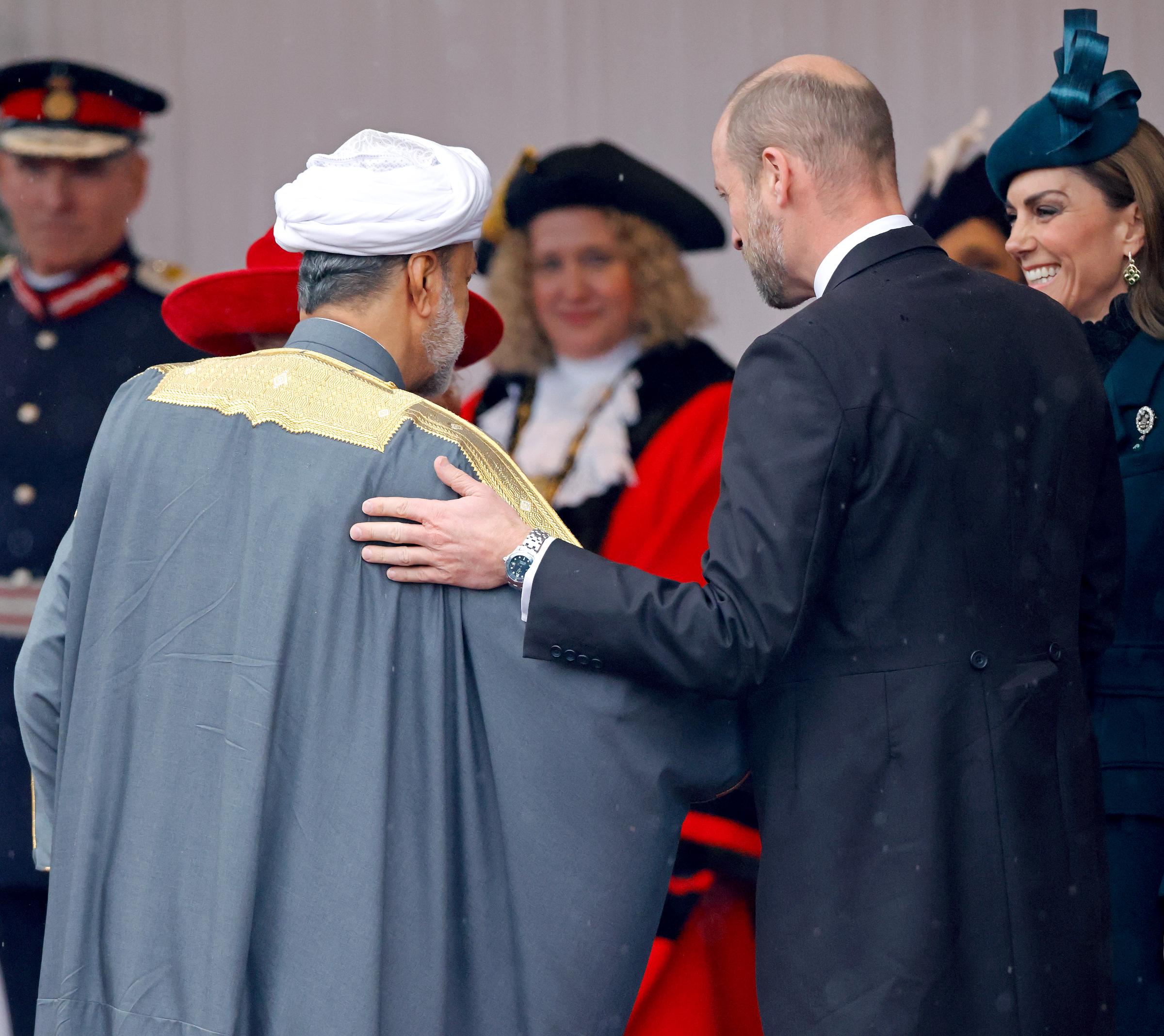 Prinz William begrüßt Sultan Haitham bin Tarik von Oman am 20. Oktober 2026 herzlich auf der königlichen Tribüne an der Datchet Road in Windsor, England, und läutet damit den Beginn des dreitägigen Staatsbesuchs ein. Im Profil zu sehen, in einem formellen dunklen Morgenmantel, legt der Prinz von Wales dem Sultan liebevoll die Hand auf die Schulter, während Catherine, Prinzessin von Wales, im Hintergrund warm lächelt – sie trägt ihren smaragdgrünen, maßgeschneiderten Fascinator von Juliette Millinery und ein hochgeschlossenes Spitzenensemble. | Quelle: Getty Images
