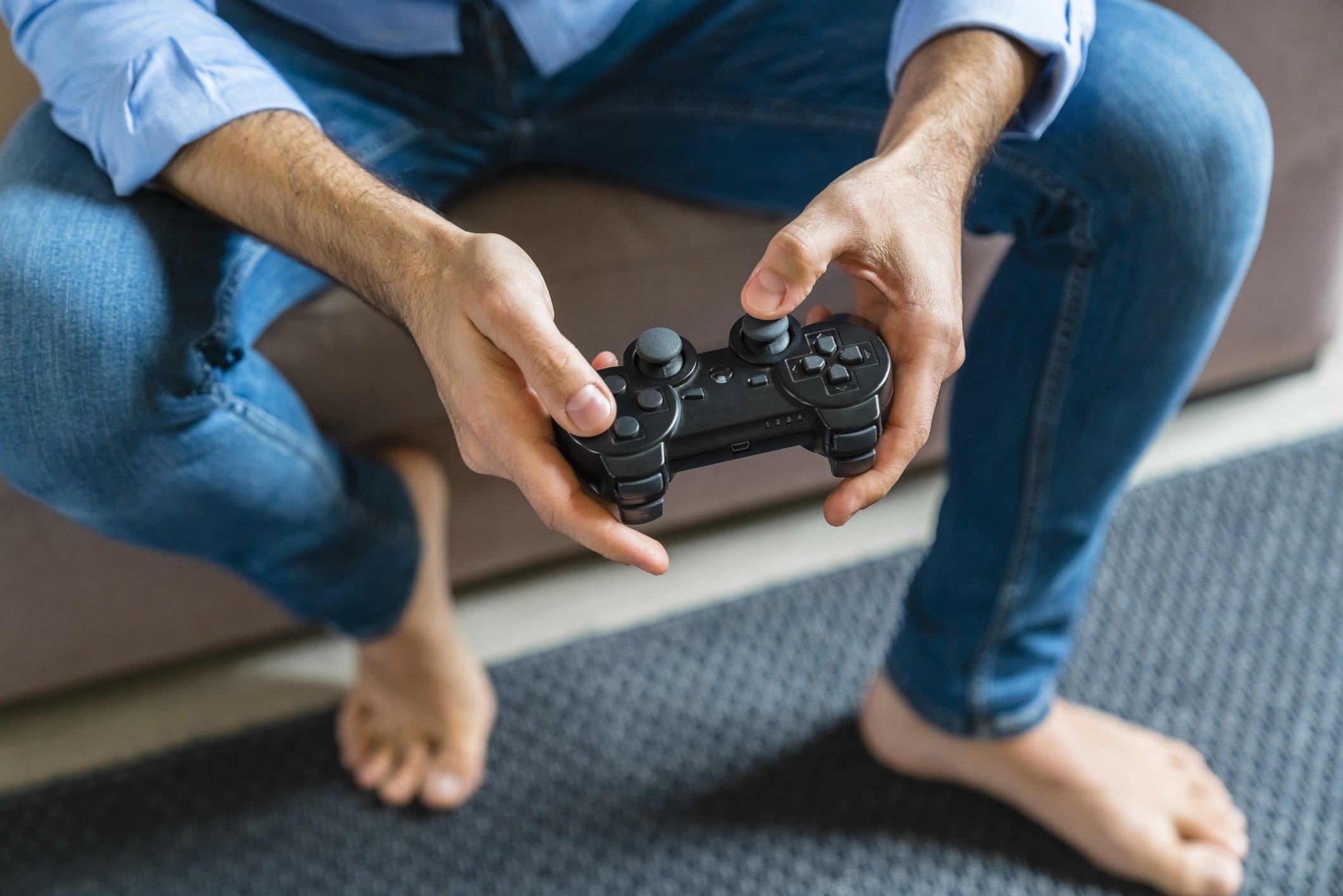 Hände des Mannes, der zu Hause Computerspiel spielt | Quelle: Getty Images