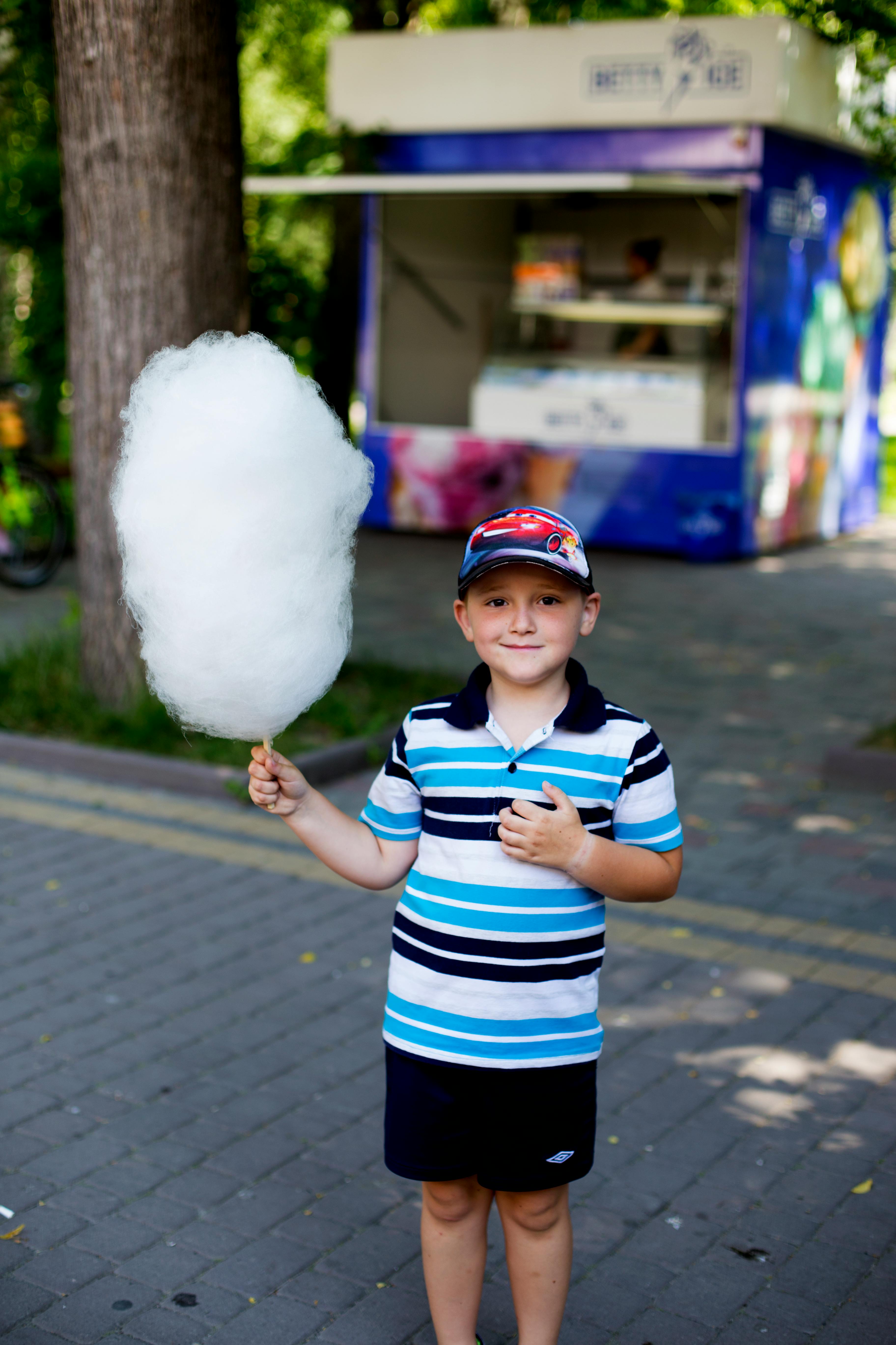 Ein Junge posiert mit Zuckerwatte | Quelle: Pexels