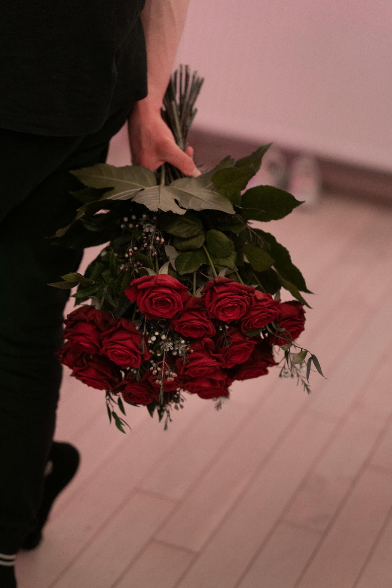 Ein Mann hält einen Strauß roter Rosen | Quelle: Pexels