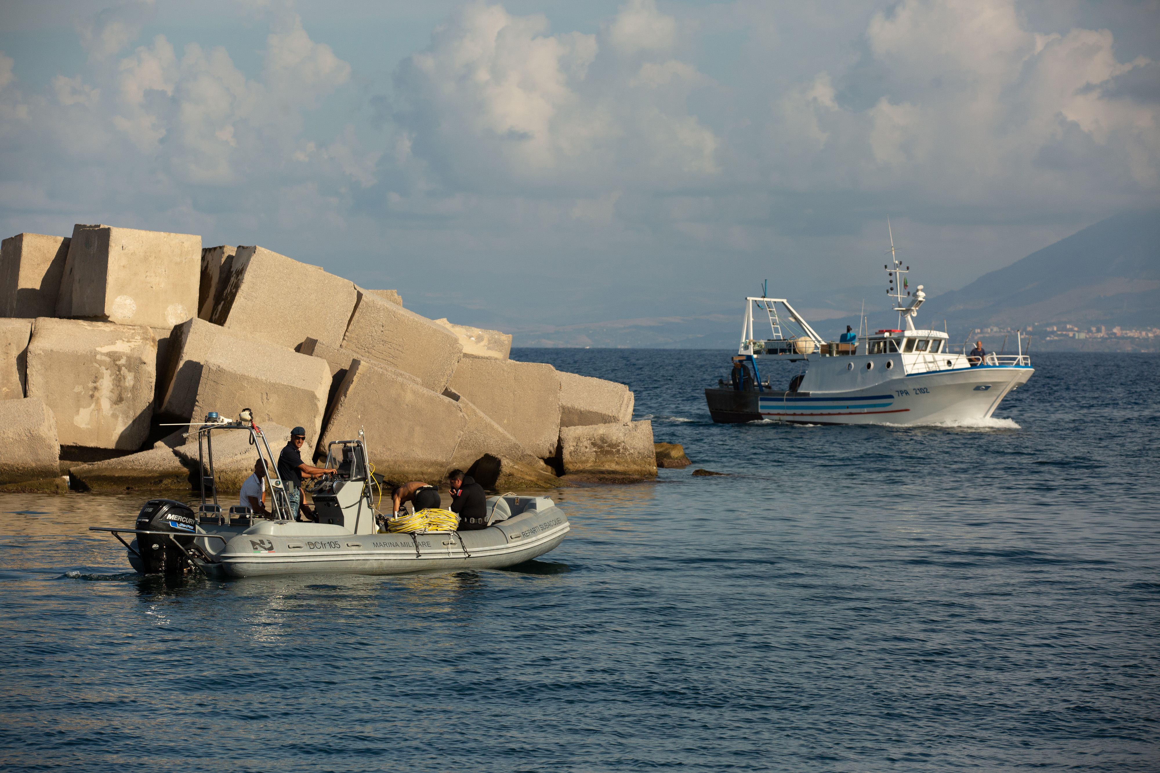 Ein Fischerboot passiert Taucher während der Suchaktion nach Mike Lynchs Luxusyacht Bayesian vor der Küste von Porticello, Italien, am 22. August 2024. | Quelle: Getty Images