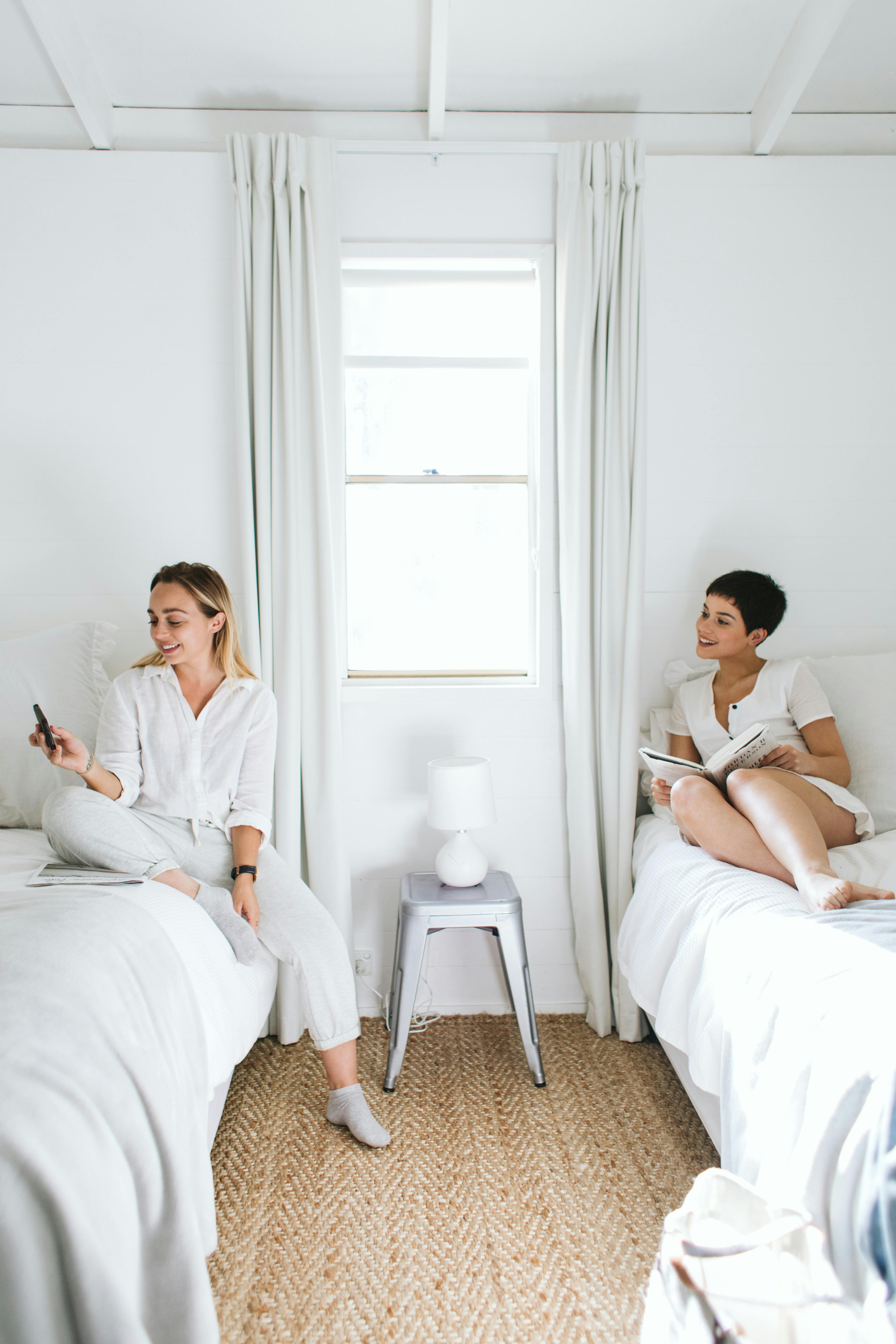 Zwei Frauen sitzen auf einzelnen Betten | Quelle: Pexels