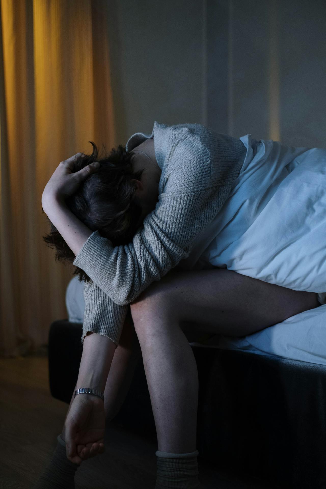 Eine depressive Frau sitzt auf ihrem Bett | Quelle: Pexels