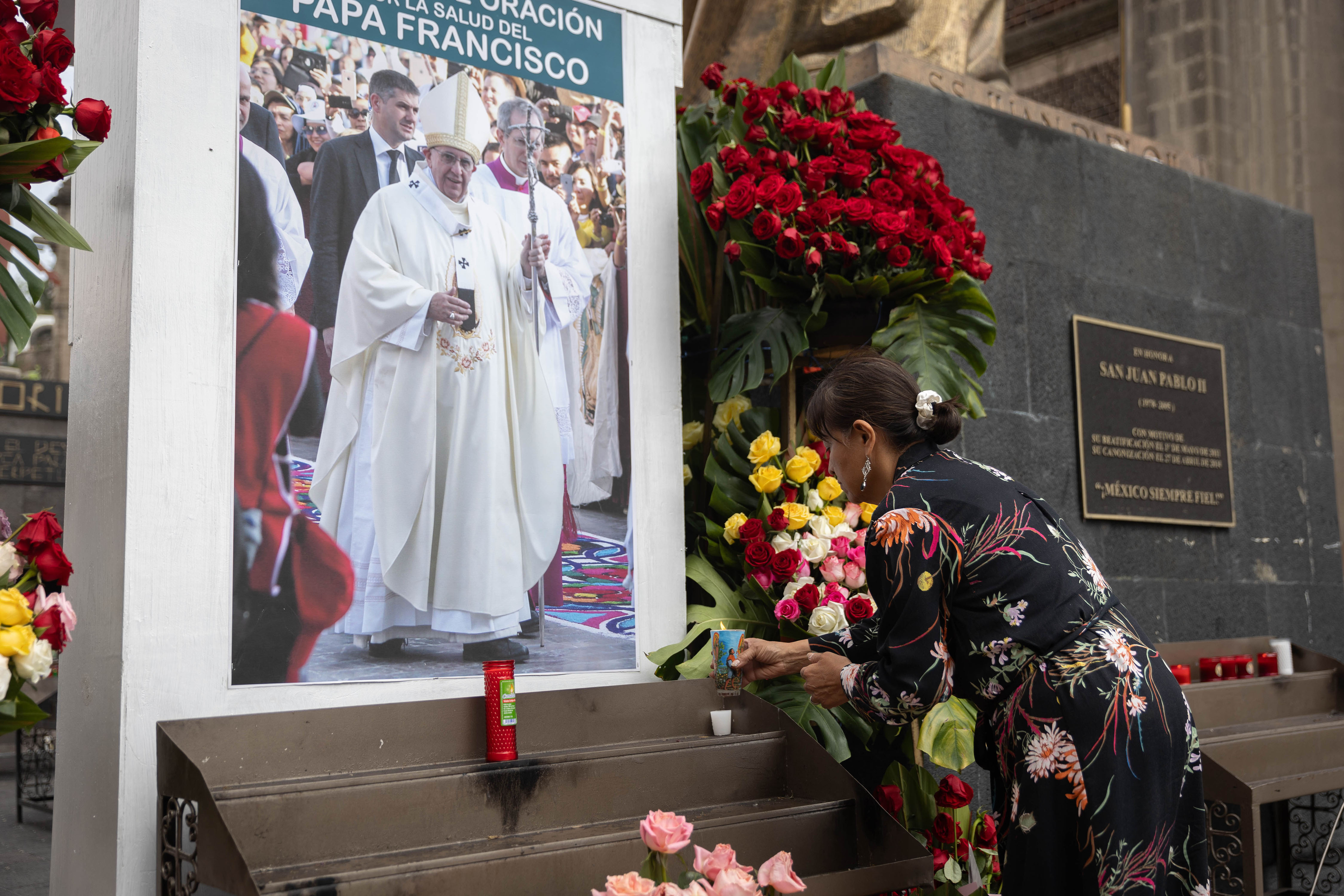 Eine Frau stellt eine Kerze vor einem Bild von Papst Franziskus vor der Basilika de Guadalupe in Mexiko-Stadt, Mexiko, am 23. Februar 2025. | Quelle: Getty Images