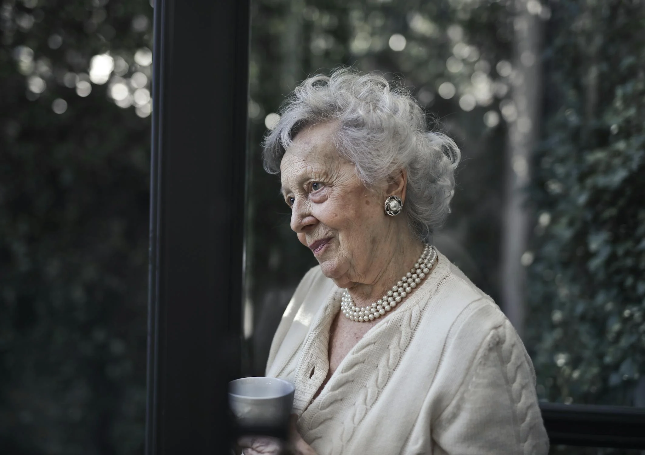 Eine Frau mit einer Kaffeetasse auf ihrer Terrasse | Quelle: Pexels