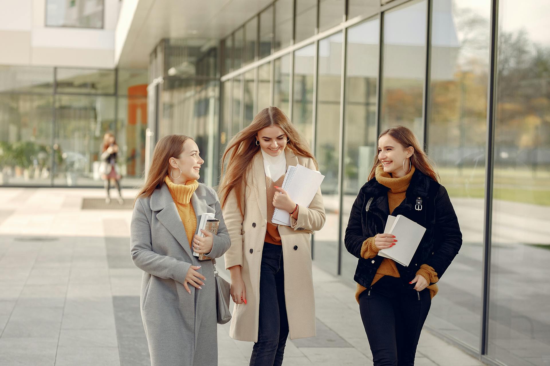 Drei Studentinnen lächeln, während sie über ihren Tag an der Uni sprechen | Quelle: Pexels