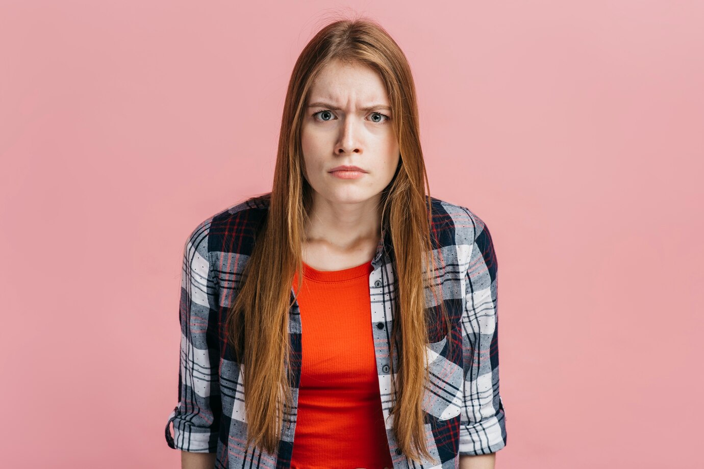 Eine stirnrunzelnde, verwirrte Frau | Quelle: Freepik