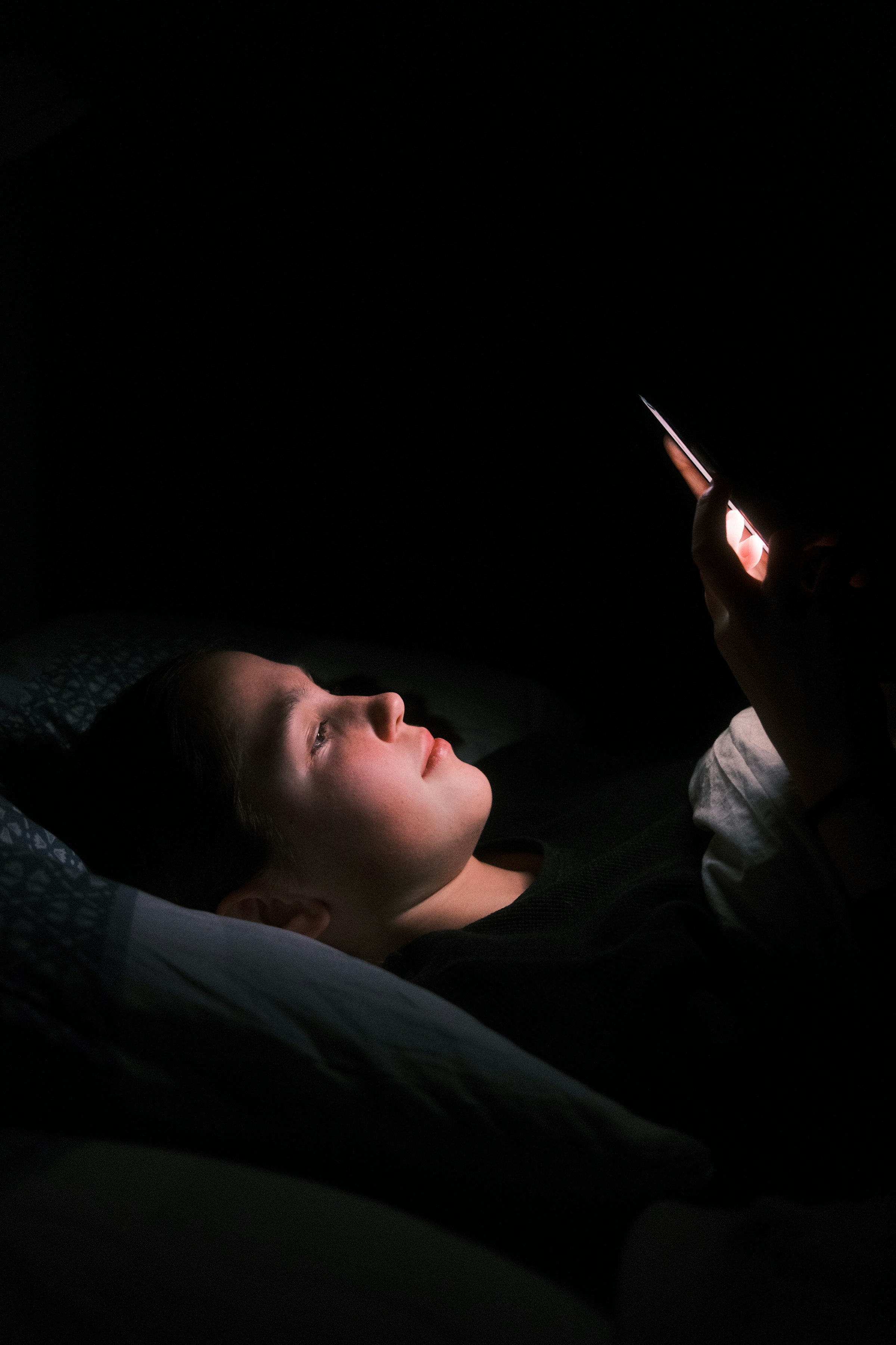 Eine Frau, die nachts im Bett ihr Telefon benutzt | Quelle: Unsplash